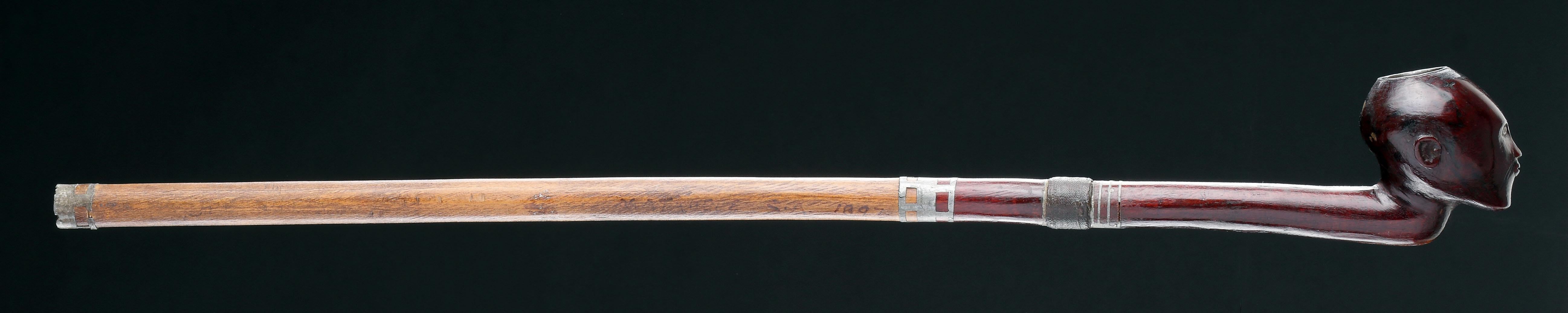 Exceptionnelle pipe nguni du Cap oriental avec son fourneau et son tuyau 
Bois, métal
Inscription ancienne et datée : '1892' 
Afrique du Sud 
19ème siècle 

Taille : 45.5cm de long - 18 ins long 

Provenance : 
Taylor A Dale, Sante Fe
Ex Collection