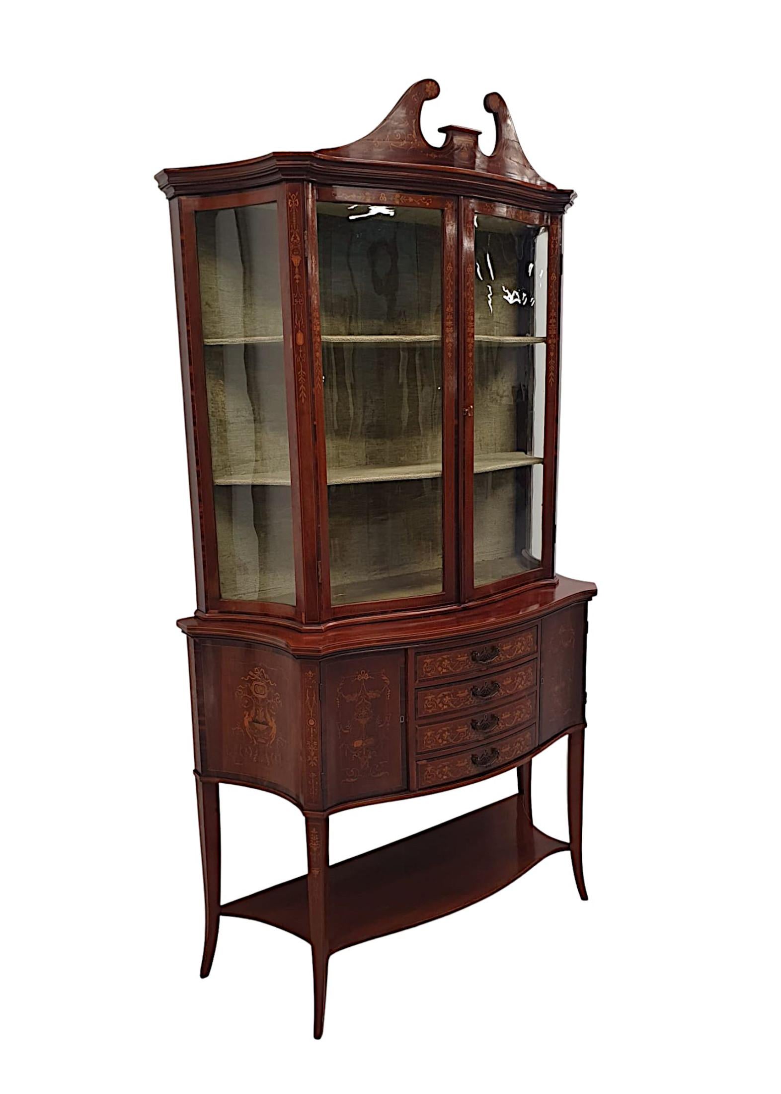 An exceptional Edwardian mahogany display case attributed to Edward and Roberts, London, with gorgeous patination, line inlaid and with exquisite marquetry detail depicting Neoclassical motifs of urns, ribboned swags of foliate, scrolls and