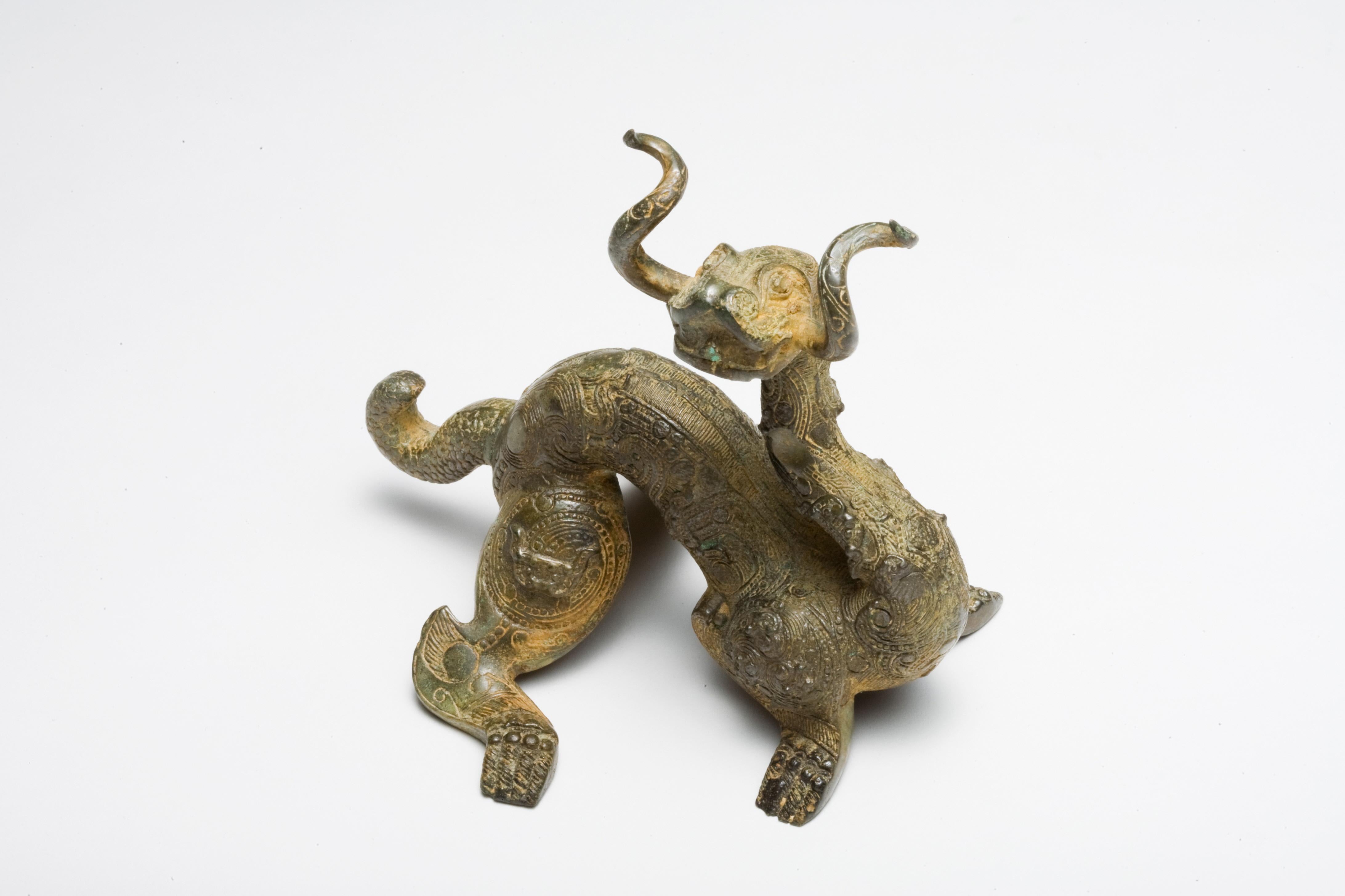 An art piece presumably from the Six Dynasties period in China, spanning from the 3rd to the 6th centuries. This era is known for its political fragmentation but also significant cultural and artistic development.This dragon sculpture exemplifies