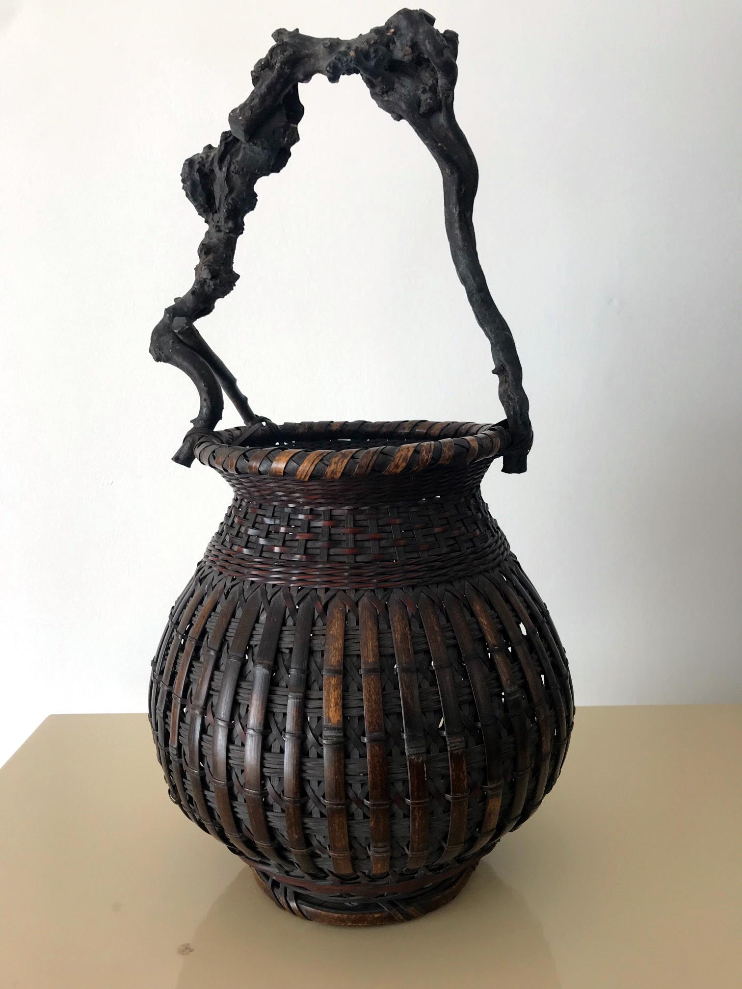 A sculpture of its own right, this antique Japanese bamboo basket from an unknown artist is from the late Meiji Period (1868-1912), likely turn of the 20th century. It features a regal form that derived from the classic Chinese basket but with a