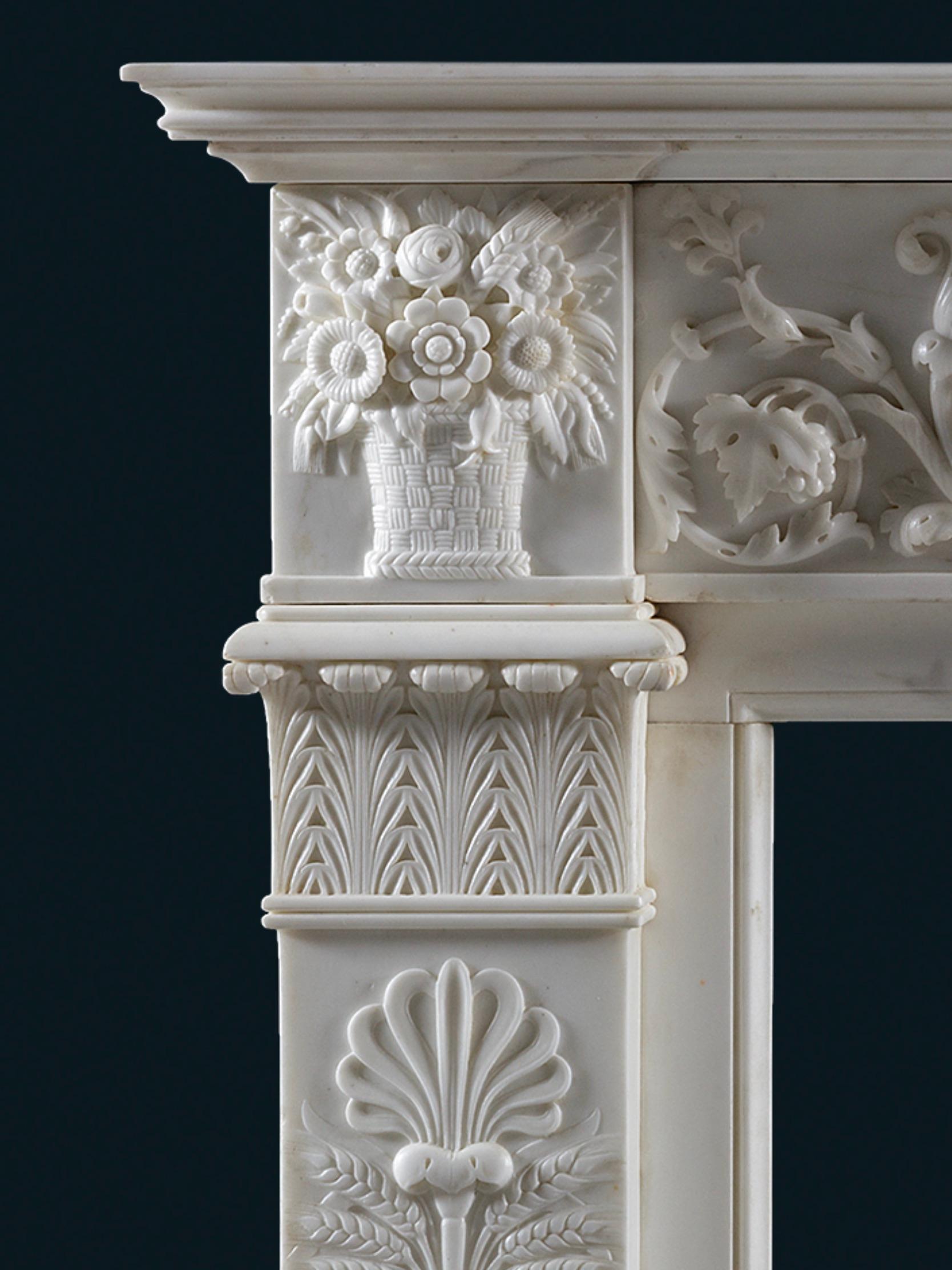 Cheminée en marbre statuaire de style Régence anglaise du début du XIXe siècle, sculptée en Italie dans la plus haute qualité, avec des découpes nettes et profondes dans la décoration sculpturale. La tablette centrale représente une scène de