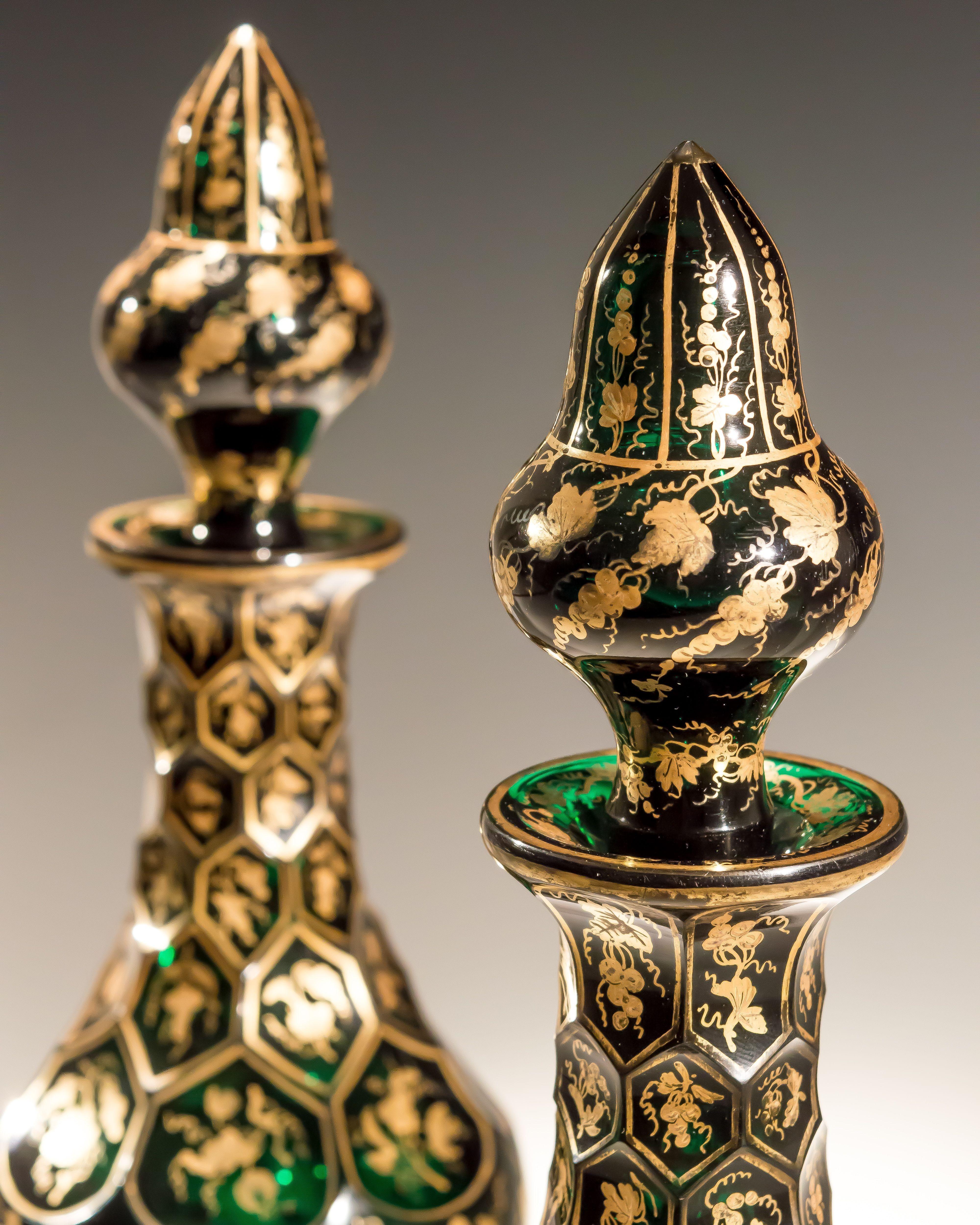 An exceptional pair of green decanters finely hand decorated with gilt fruiting vines with corresponding stoppers, possibly unique.
Measures: Height 34 cm (13 1/2