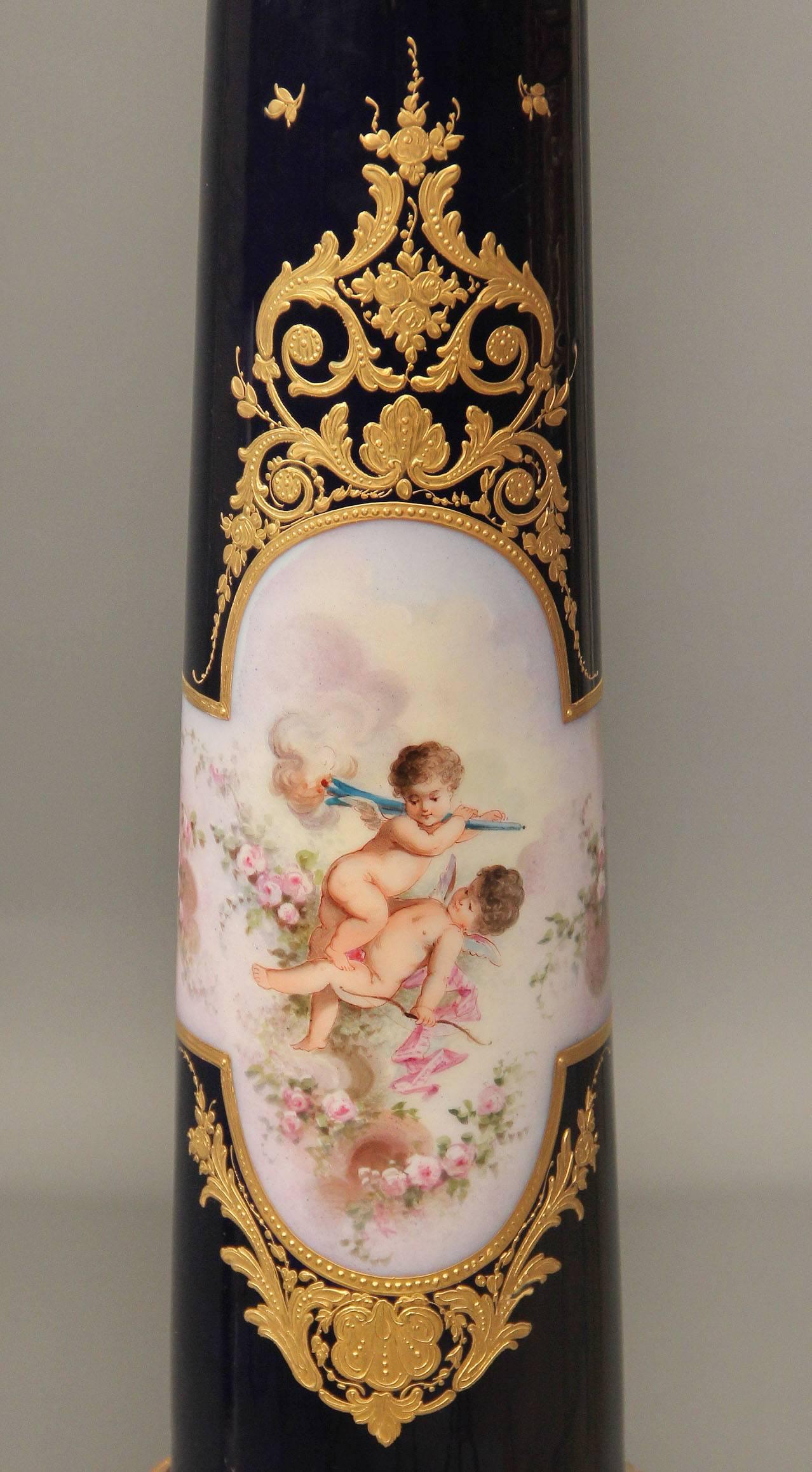An exceptional pair of late 19th century gilt bronze mounted onyx and Sèvres style pedestals.

Square onyx top above a columnar support painted with lovely scenes of women and cherubs, the backs painted with musical instruments, trophies and