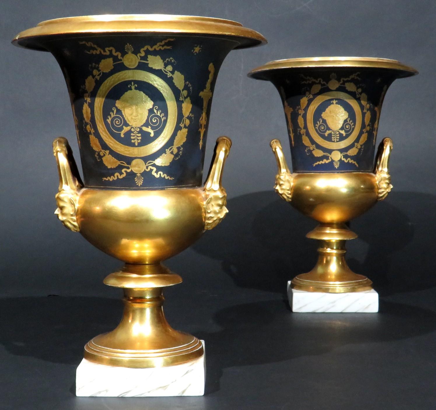 Un par de grandes y llamativos jarrones de porcelana dorada del siglo XIX con una presencia fuerte pero elegante. Ambos jarrones están decorados con motivos neoclásicos dorados y estarcidos sobre un fondo azul cobalto mate, sobre bases doradas