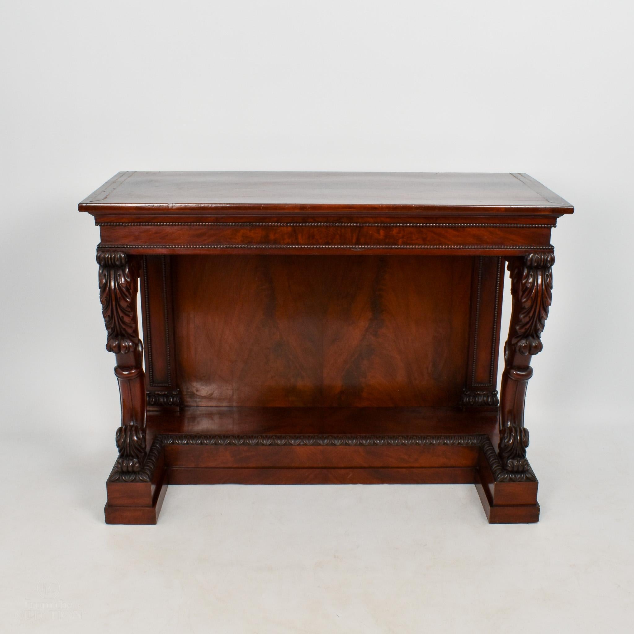 An exceptional pair of William IV Mahogany console tables circa 1840. Exceptional rich colour and quality. Possibly made by Gillows with brass stringing to the top and beautifully carved supports to the front on carved feet and with a panel back.