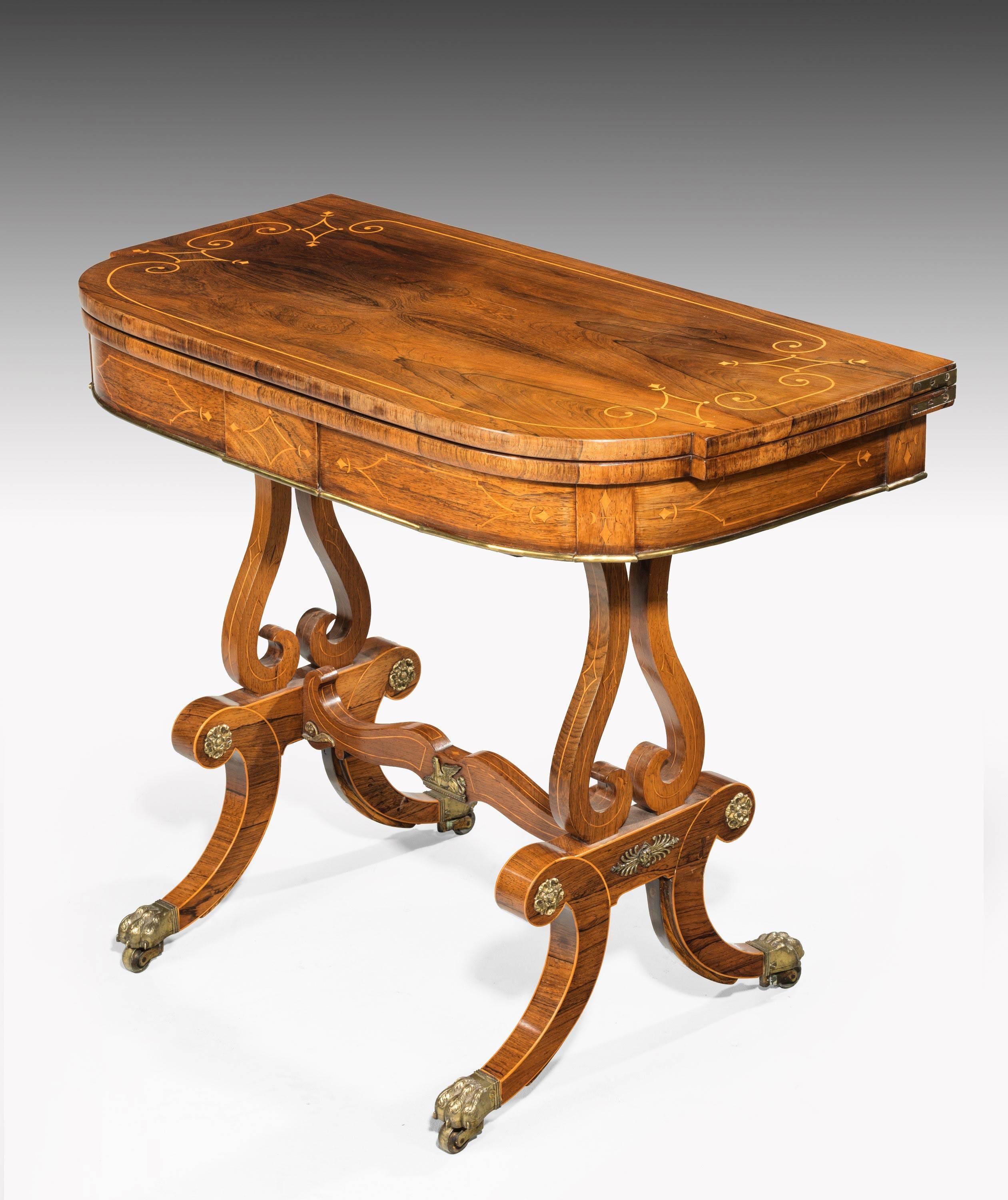 An exceptional Regency period rosewood card table with a broken bow front. The top edge crossbanded with finely shaped lyre supports with a wavy stretcher. Crossbanded on most of the surfaces with good English bronze mounts which are original. The
