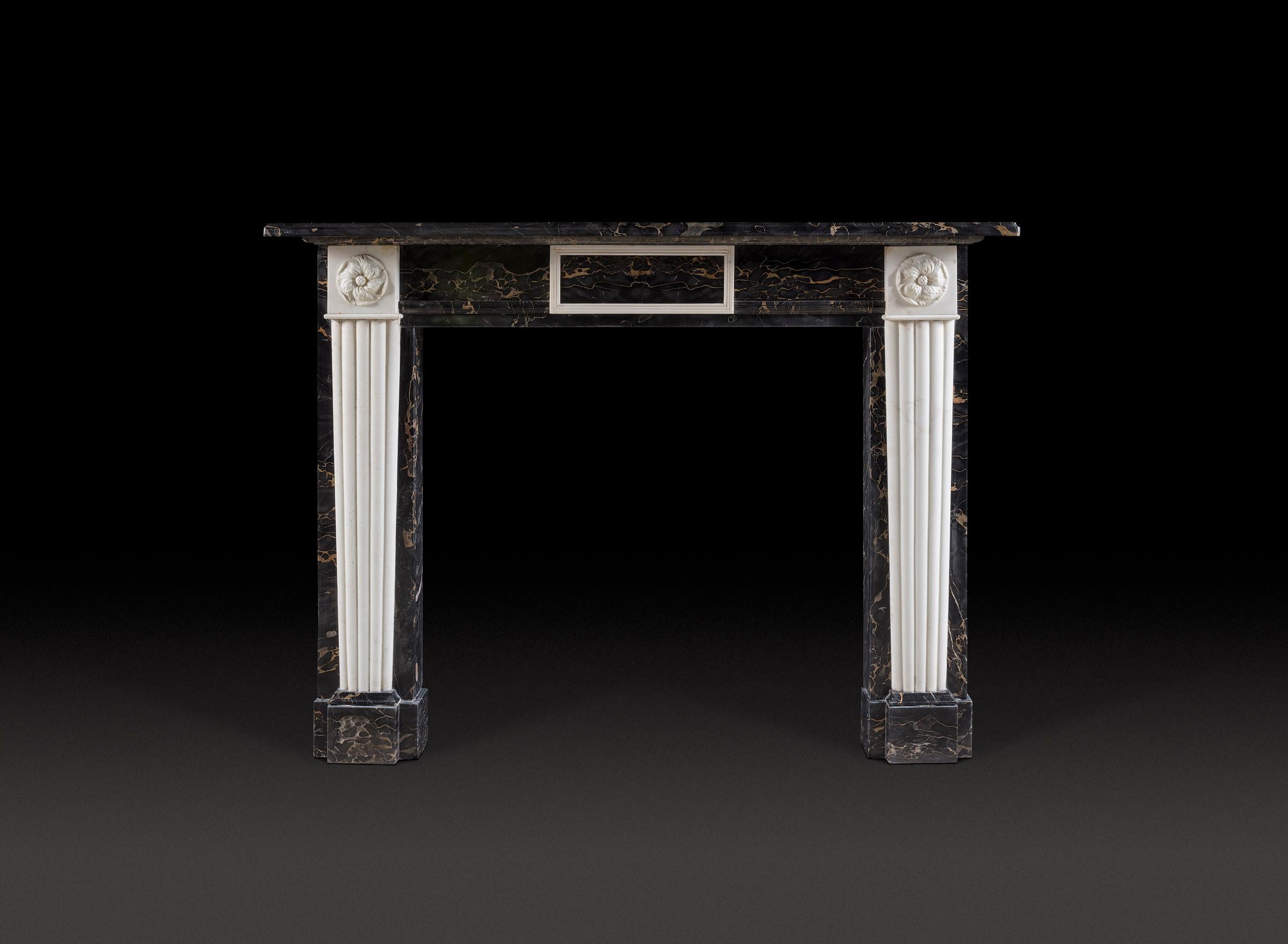 An exceptional, early 20th century, Regency style chimneypiece in Portoro Nero and statuary marbles. The central tablet is a book matched specimen veneer of phenomenal quality, bordered by a moulded statuary frame, flanked by further Portoro. The