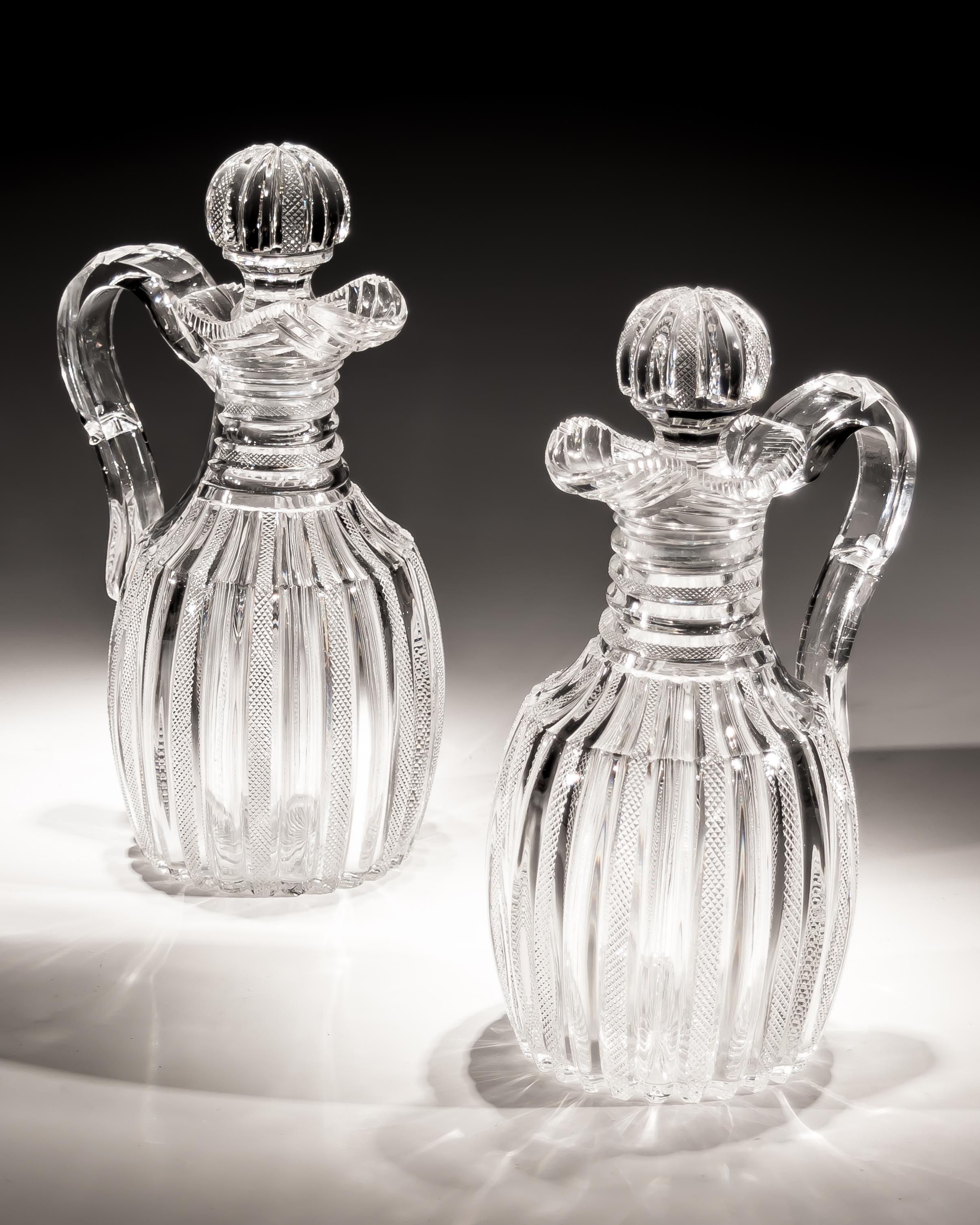 An exceptional suite of pillar and file cut glass jugs by John Blades consisting of two claret jugs with applied cut handles and pillar and file stoppers, the two water jugs cut in the same manner with scalloped rims.

Claret jugs size:
Height