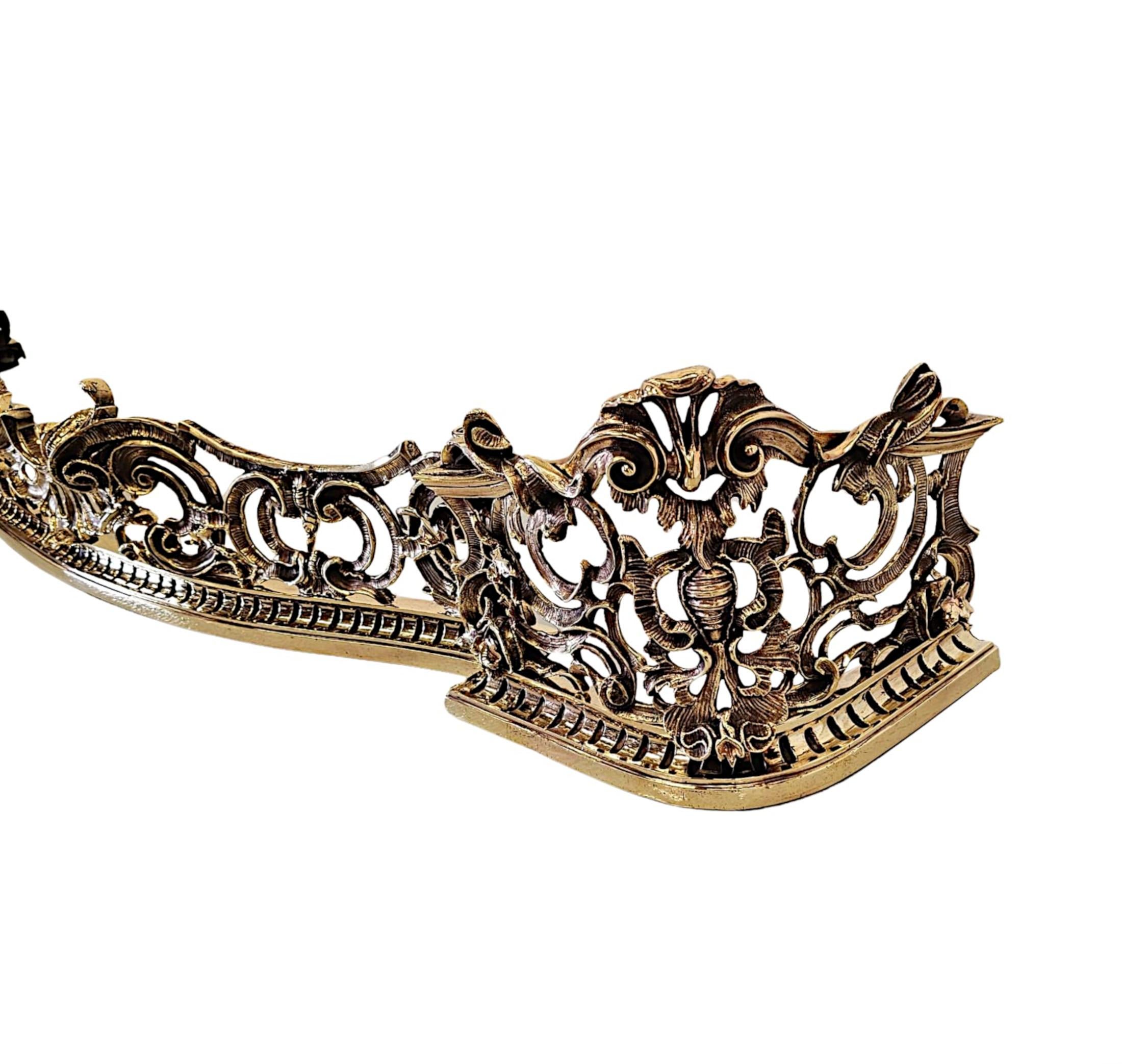 An exceptionally rare and fine 19th Century beautifully patinated cast brass curb fender in the Roccoco manner.  The elegantly pierced frieze of serpentine form with stunningly detailed motifs throughout, comprising of an arrangement of ruffles,