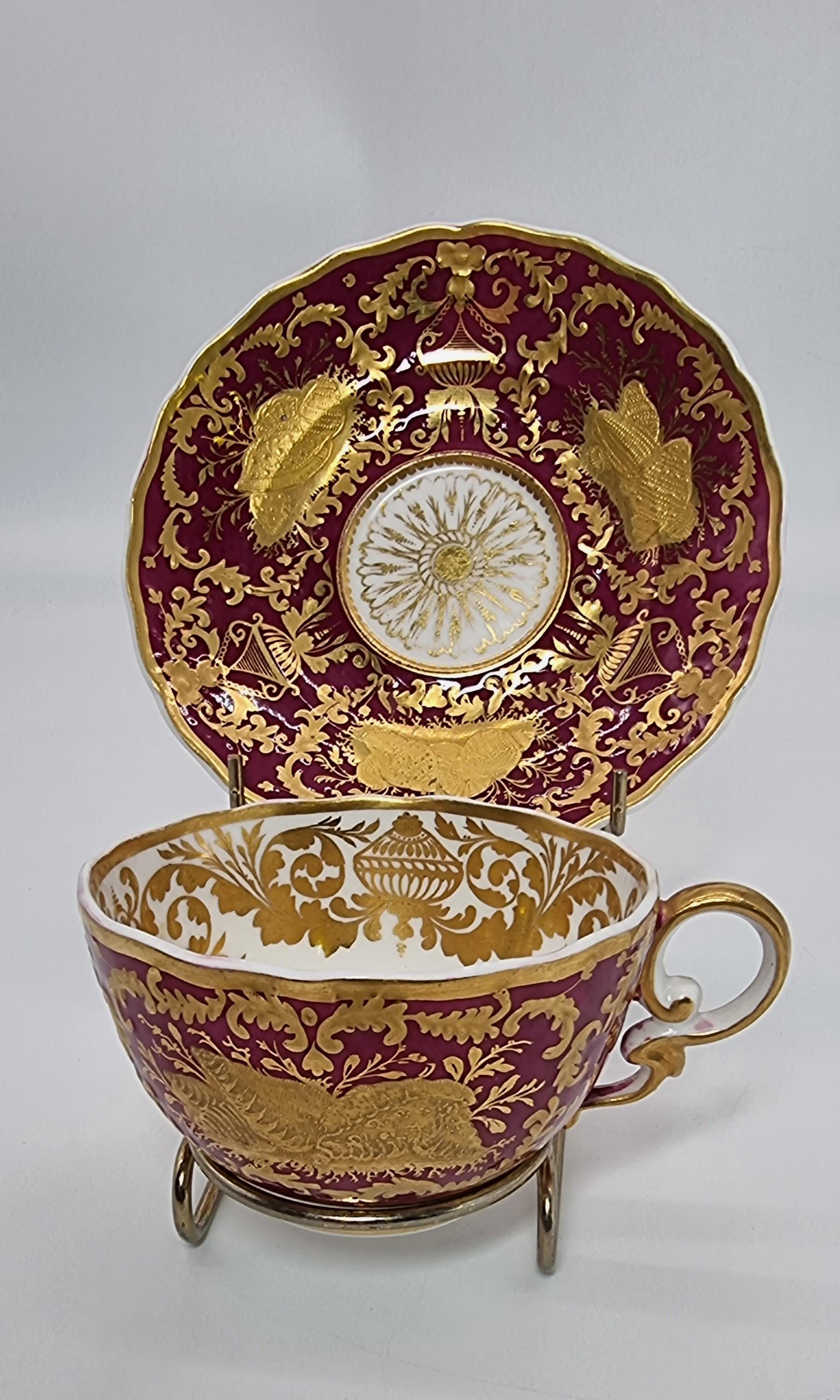 An exquisite and rare early 19th century Spode cabinet cup and saucer.
This beautiful and richly decorated Spode cabinet cup and saucer were made at this high quality English porcelain factory, Circa 1830.  It has a deep plum red ground with a white