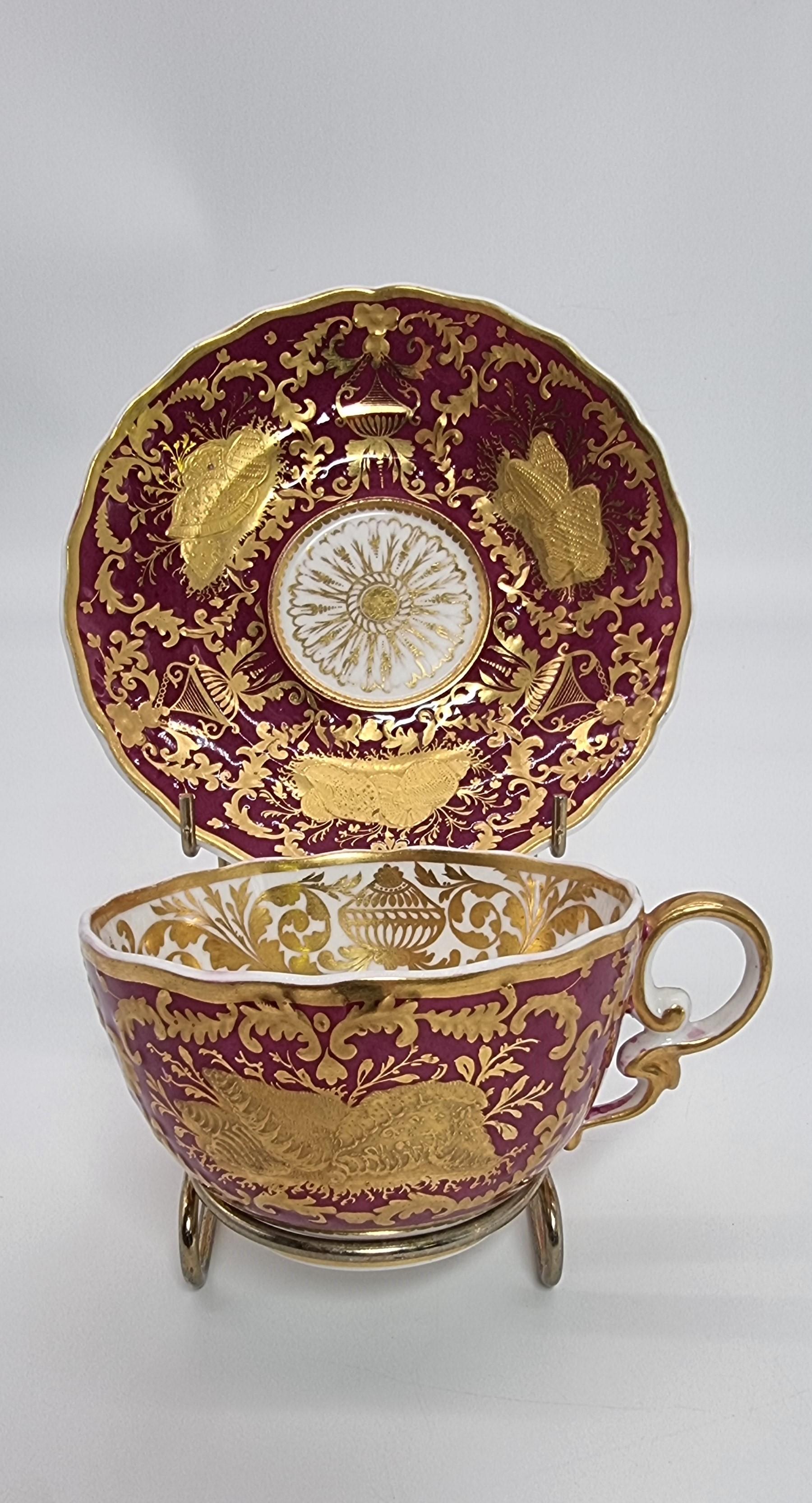 An exquisite and rare early 19t C Spode cabinet cup and saucer.
This beautiful and richly decorated Spode cabinet cup and saucer were made at this high quality English porcelain factory, Circa 1830.  It has a deep plum red ground with a white