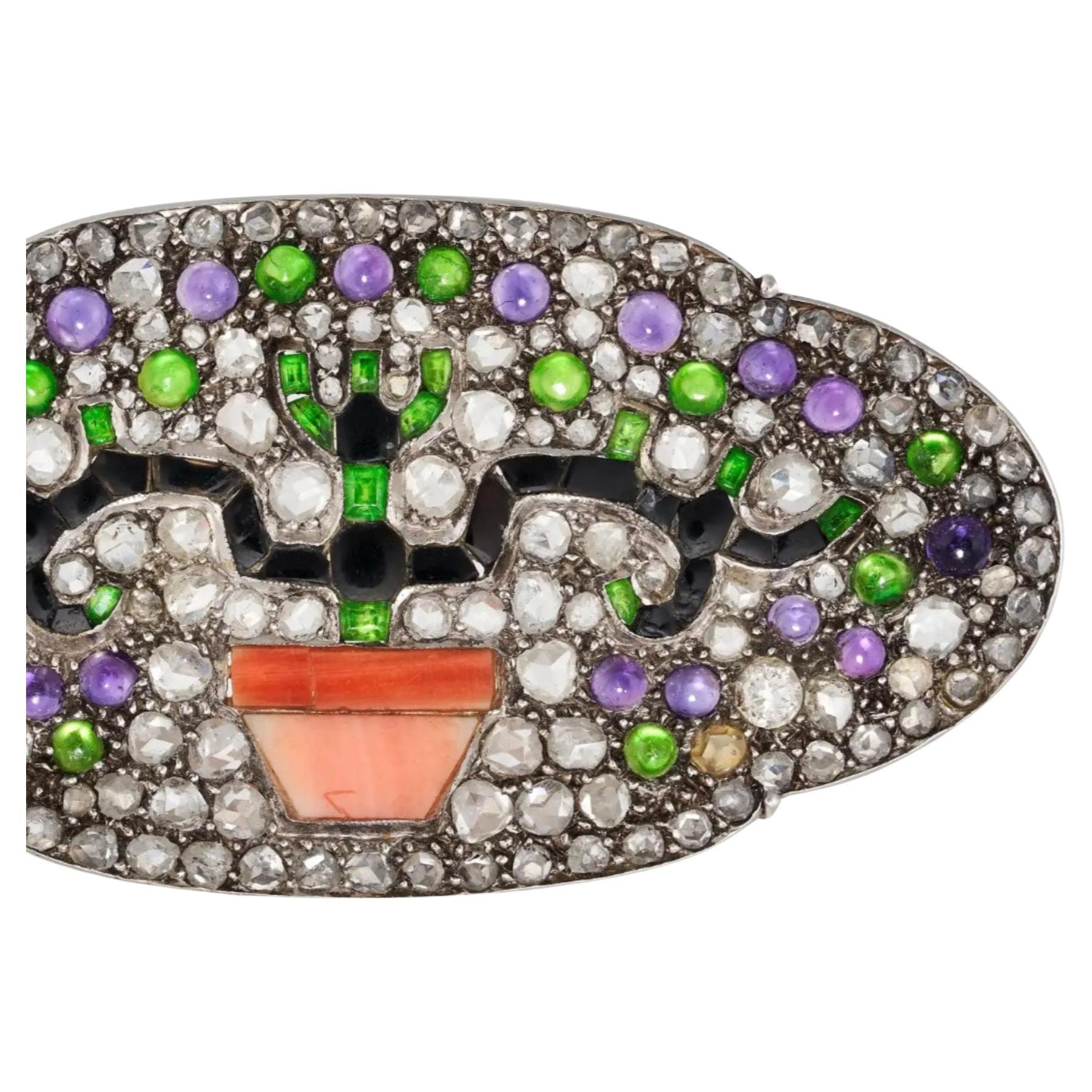 This art deco brooch is of magnificent design and highlights a lovely combination of gems. The subject is an onyx symmetrical bonsai tree planted  in a polished coral pot. The onyx branches provide a structure to the sparkling background of round