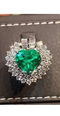 An exquisite certified 5, 77 carats of  emerald and diamonds on ring
