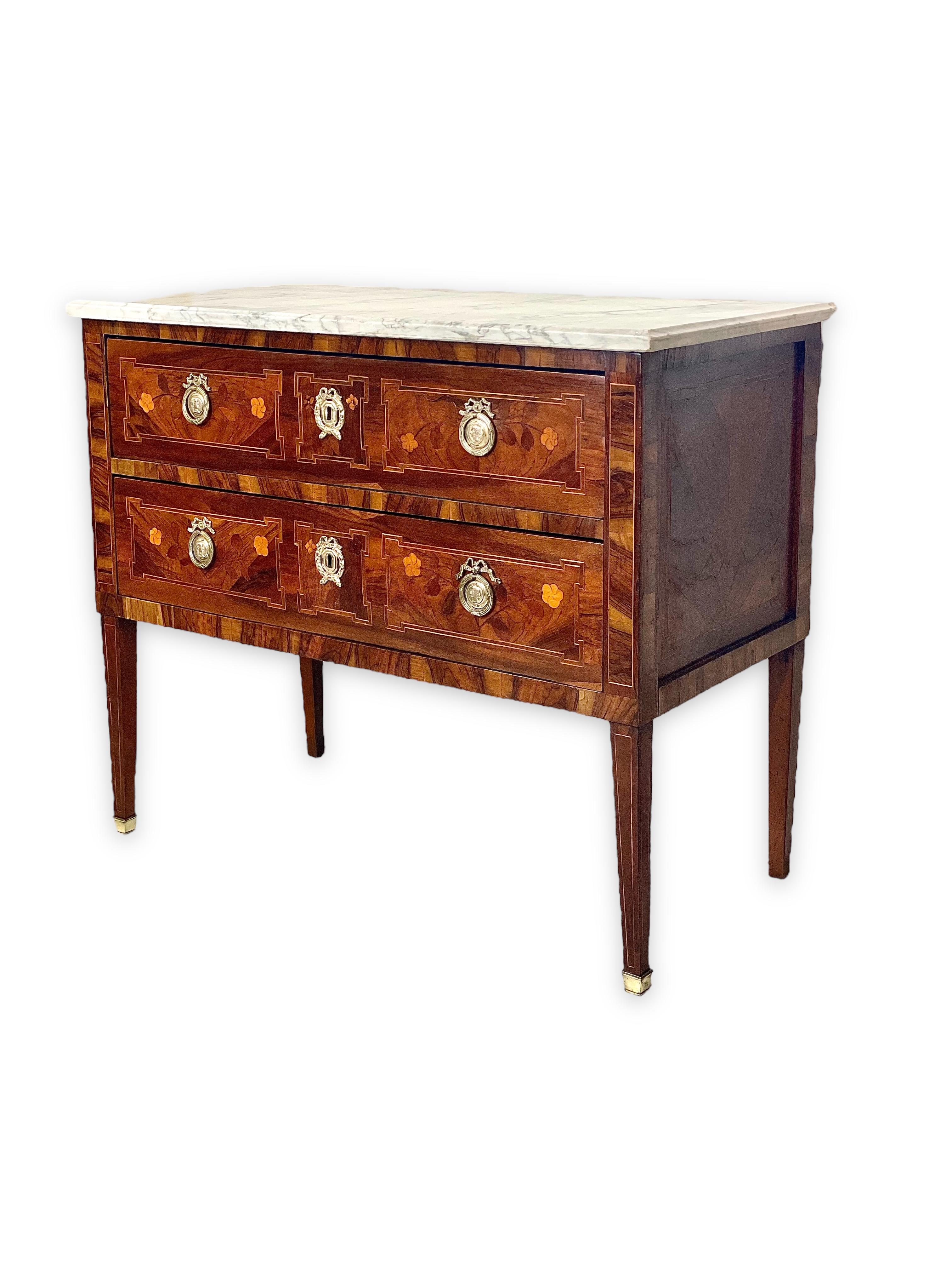 An exquisite, early 19th century Louis XVI style two-drawer 'Commode Sauteuse', with a white marble top and gilt bronze fittings. This curiously named style of commode always features two drawers perched on high legs, which gives the amusing
