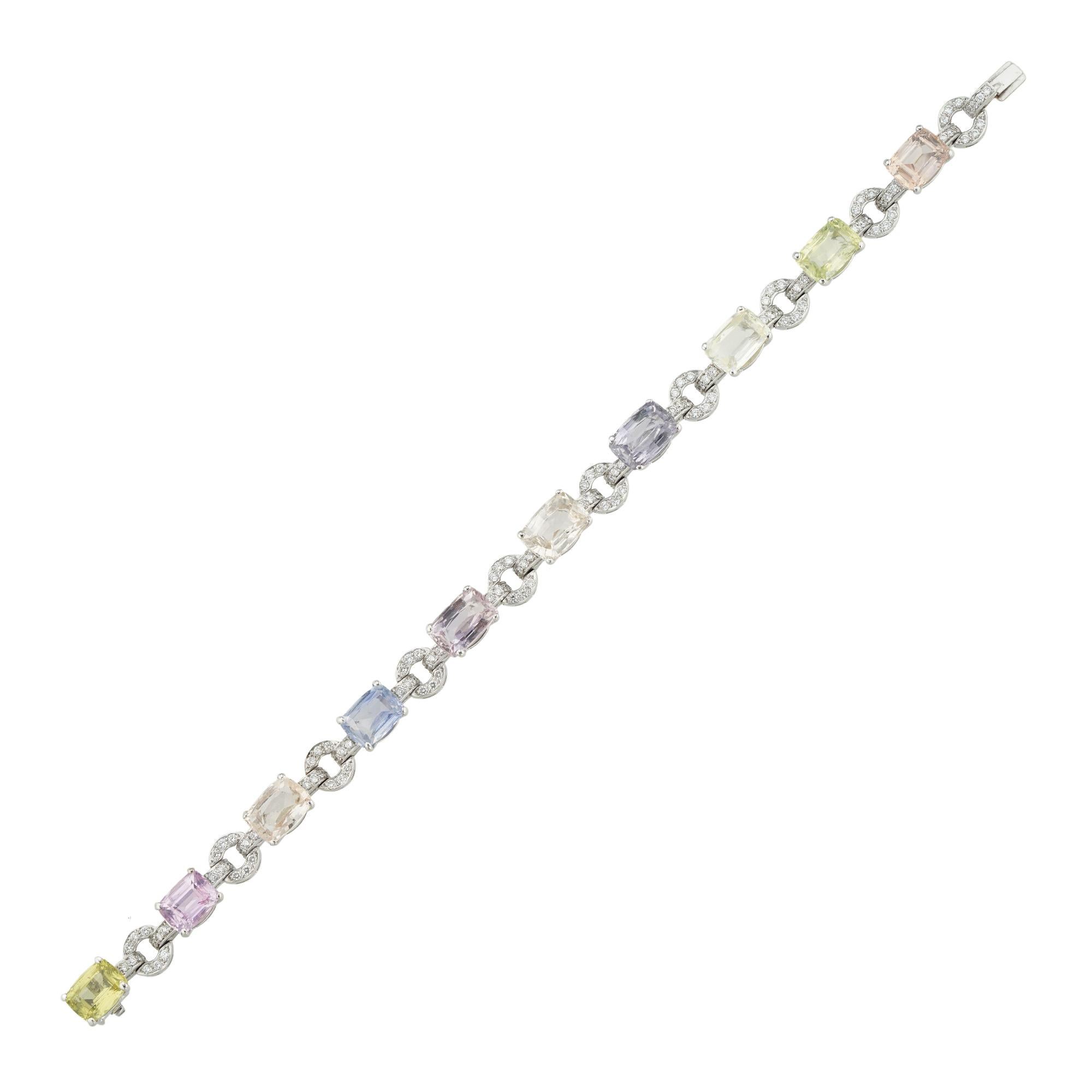 Exquisito brazalete de zafiros y diamantes, engastado con diez zafiros multicolores facetados de forma ovalada, con un peso total de 28,63 quilates, todos engastados con cuatro garras en una montura de oro blanco, las gemas conectadas por eslabones