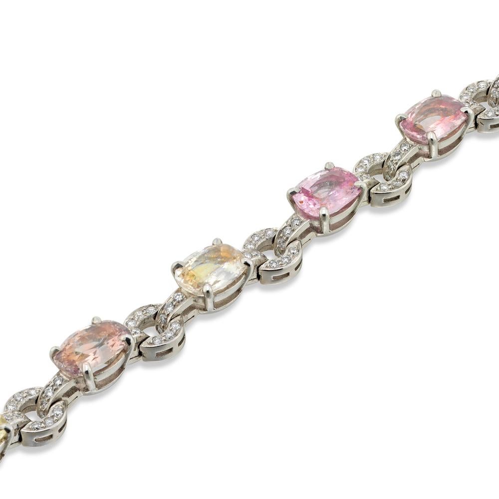 An exquisite sapphire and diamond bracelet, the bracelet set with ten oval shaped faceted multicoloured sapphires, weighing a total of 29.5 carats, all four-claw set to a white gold mount, the gems connected by circular diamond-set links, the