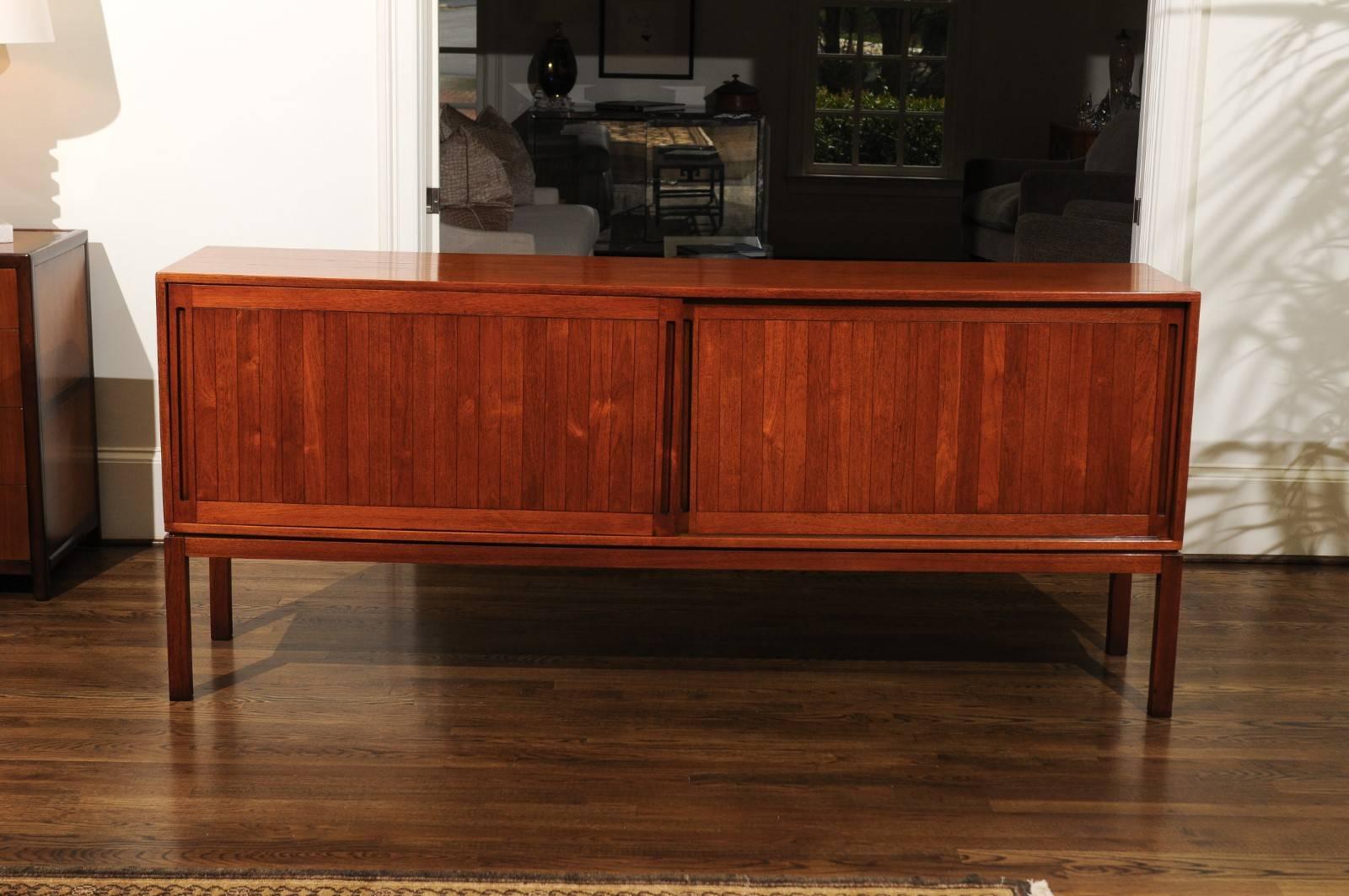 A stunning muilti-purpose cabinet or credenza, circa 1963. This particular design is routinely attributed to Kurt Ostervig. Exceptionally crafted teak construction with simple elegant lines. Beautiful finished back that allows the piece to stand