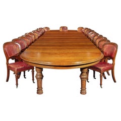 An extensive burled and figured pollard oak dining table and chairs by Gillows