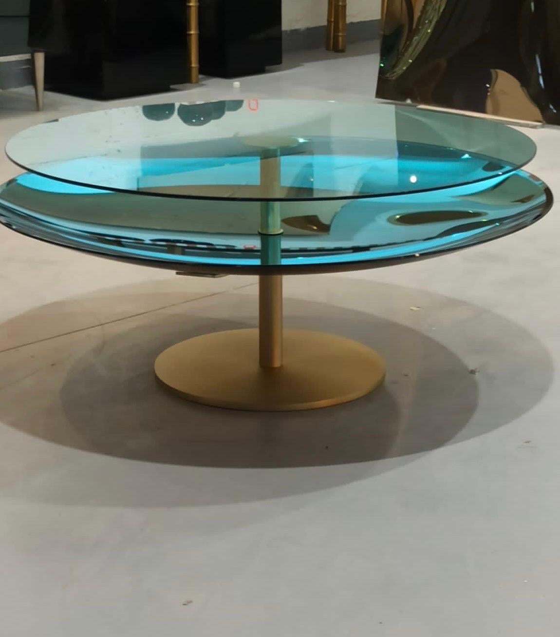 This amazing two tier coffee table consists of hand blown turquoise concave mirrored glass at the bottom and flat light blue clear glass on top supported by a solid brass structure. The table is produced by master glass blowers in Milan .
It’s