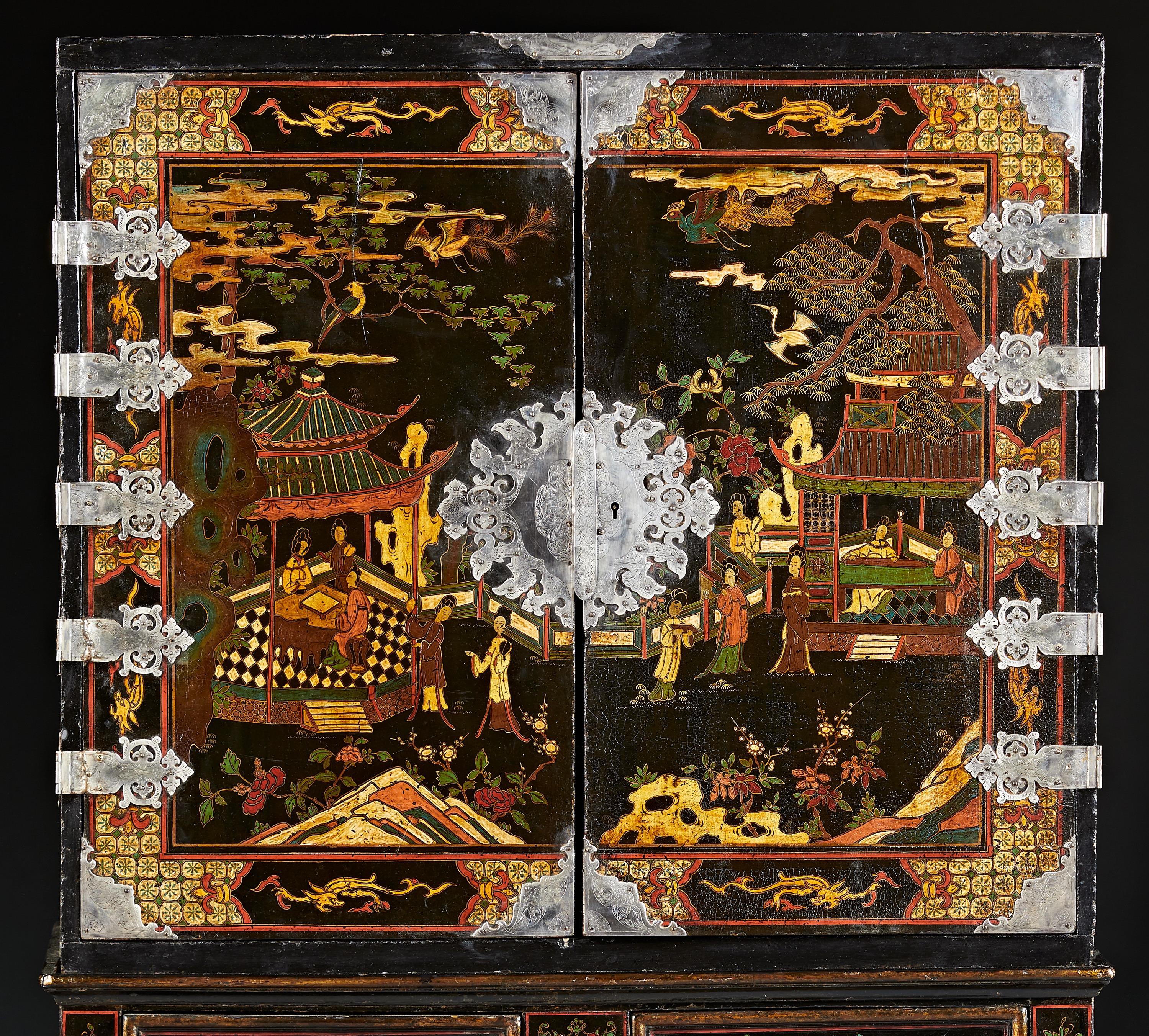 A Bantamwork or Coromandel lacquerwork decorated cabinet on cabriole frame executed in the English manner, mimicking an Asian inspired form of furniture. The upper cabinet with double doors has a fitted interior and is mounted with solid silver and