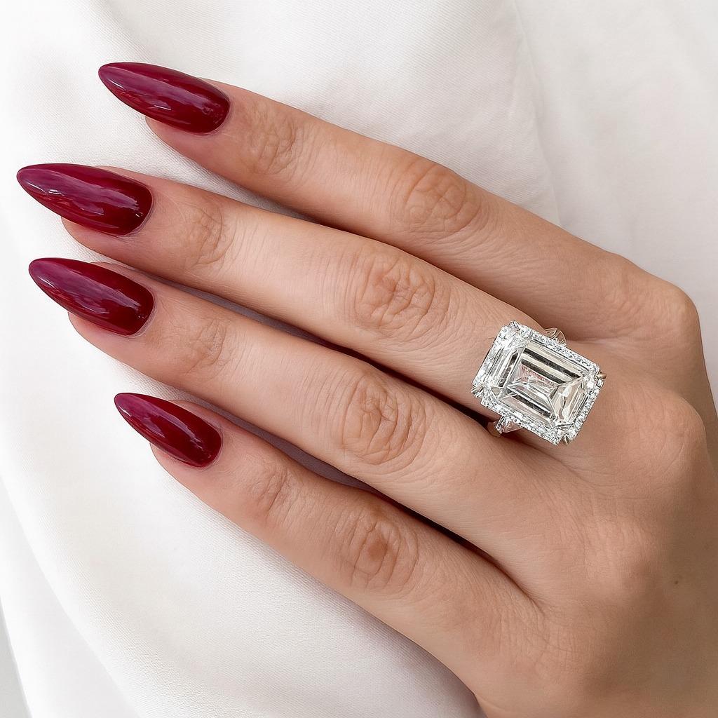 Uno straordinario anello con diamante taglio smeraldo certificato GIA da 10,01 carati, incastonato in un'intramontabile montatura in platino con classici diamanti laterali a baguette affusolati.

Il diamante principale è un esemplare notevole, che
