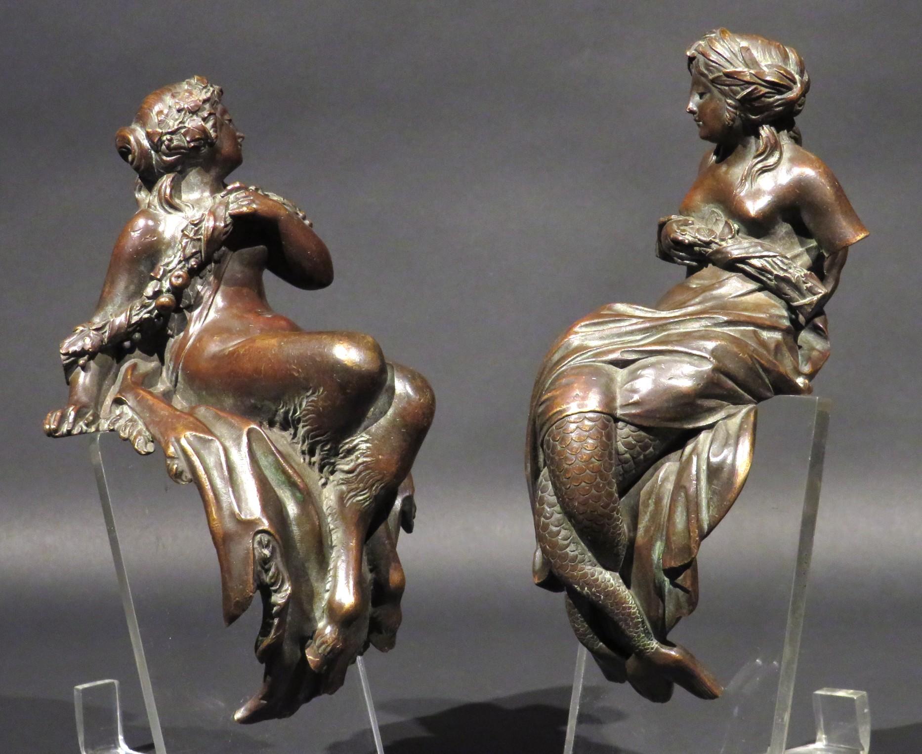 An extremely fine & highly decorative pair of early 19th century Neoclassical bronze figural furniture mounts, both depicting mythological maidens clutching fruiting sheaves - one sculpted & cast in the manner of Clodion depicting a Fauness with