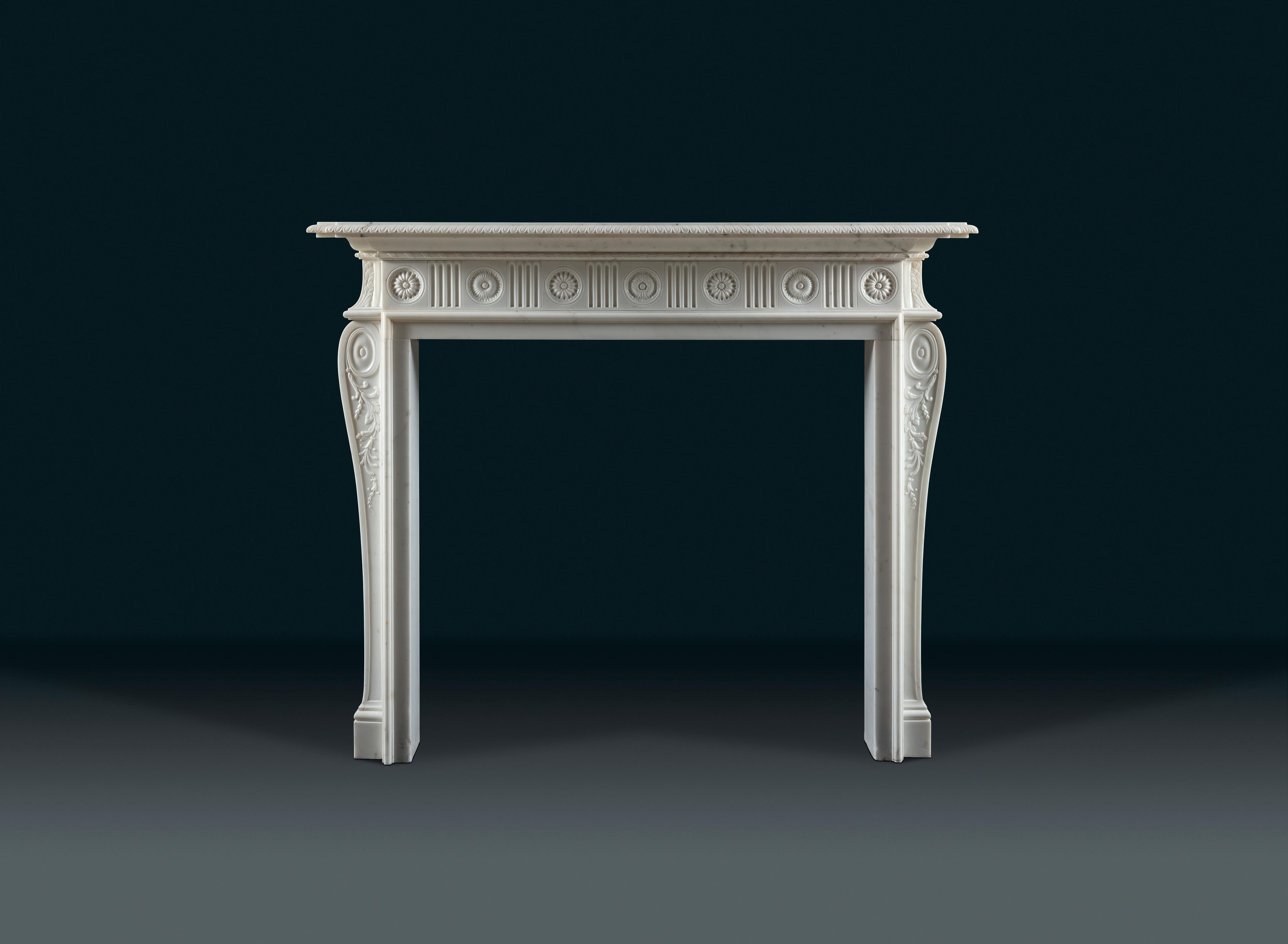 An extremely refined Adam period chimneypiece carved in white Statuary marble.
An elegant pie-crust shelf rests on the frieze, adorned with alternating floral paterae and finger flutes. Finely carved scrolls with delicate foliage decorate the side