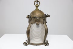 An Arts & Crafts hammered brass lantern with original opaque ribbed glass liner.