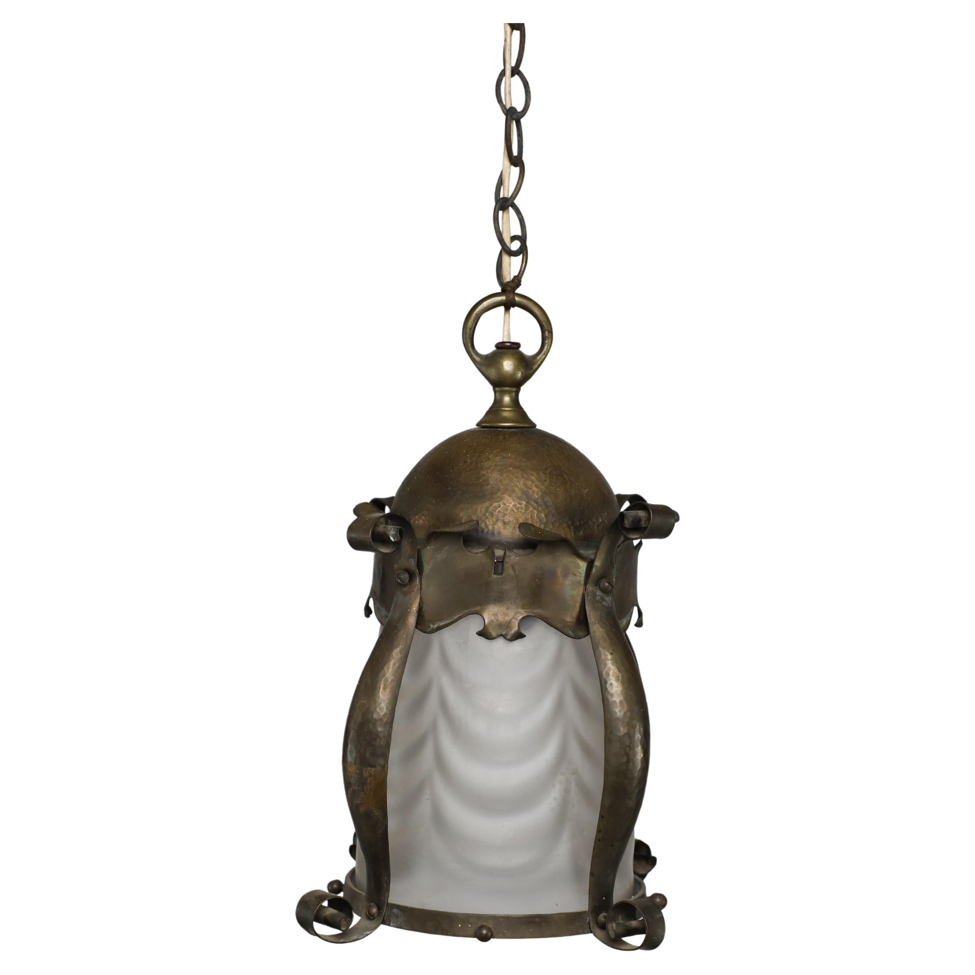 An Arts & Crafts hammered brass lantern with original opaque ribbed glass liner. For Sale