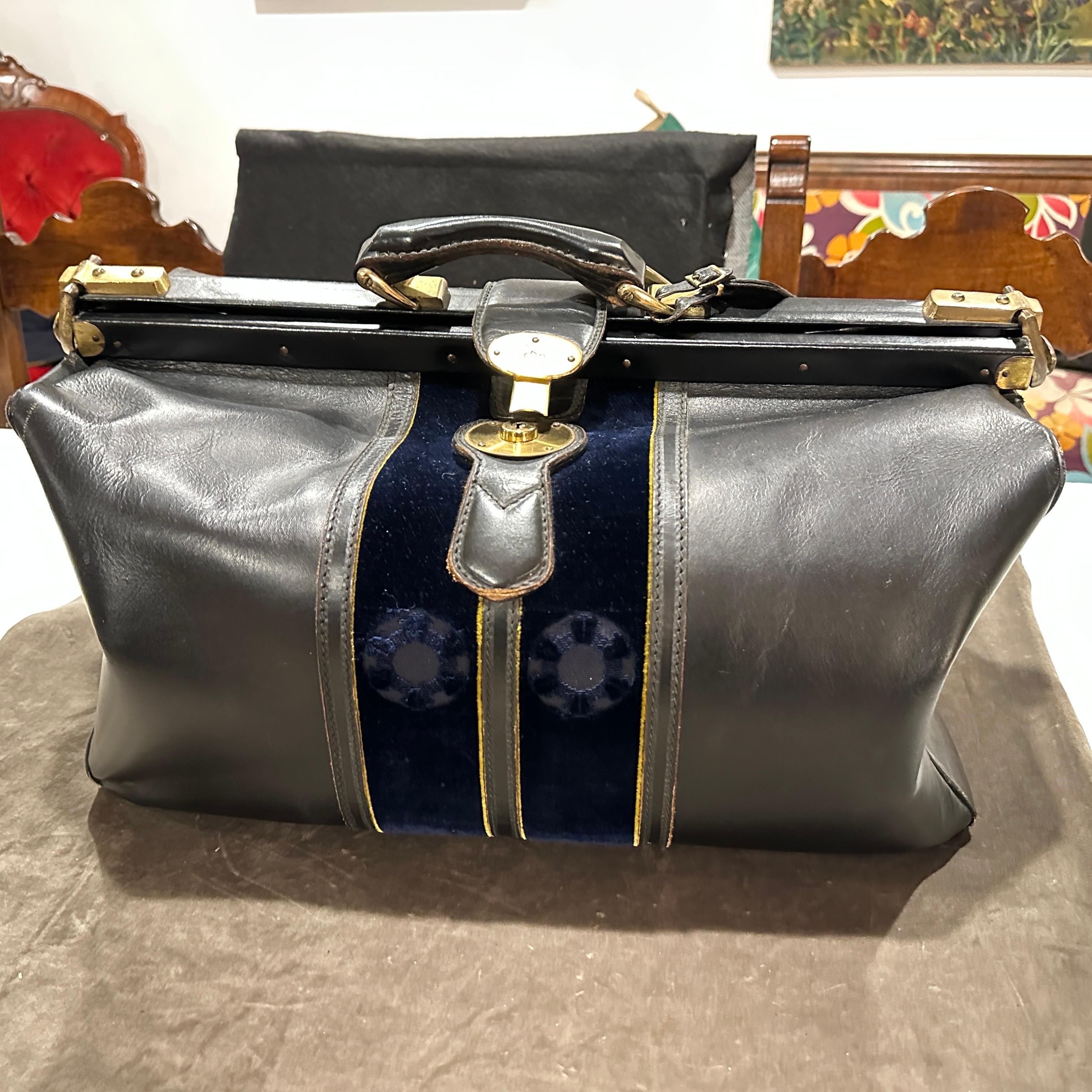 This vintage Roberta di Camerino duffel bag is a sophisticated travel essential, showcasing the iconic Italian brand's signature fusion of luxury, theatrical flair, and classic elegance.
The body of the bag is made from smooth, deep black leather,