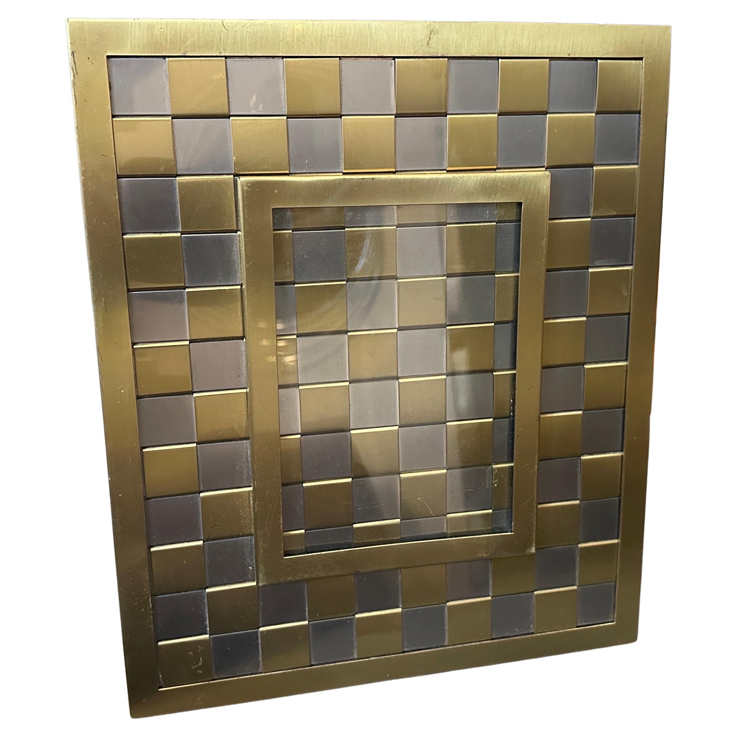 Dieser hochwertige italienische Bilderrahmen aus den 1970er Jahren im Romeo Rega-Stil ist ein emblematisches Stück der Mid-Century Modern Design-Bewegung mit einem glamourösen italienischen Touch. Schachbrettmuster aus abwechselnd gebürsteten gold-