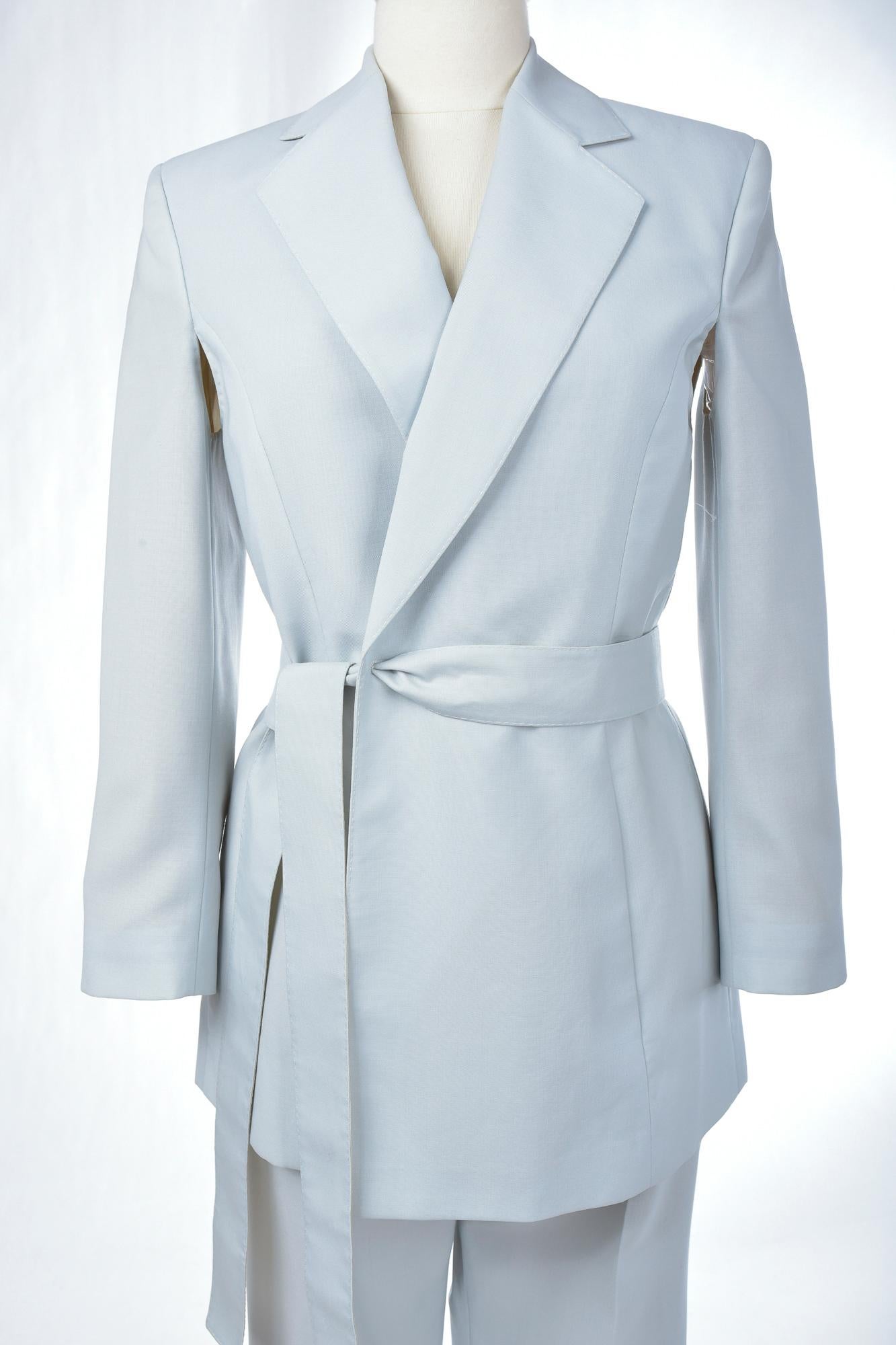 Ca. 1995 - 2000

Italien

Eleganter Smoking-Hosenanzug aus eisblauem Schurwollstoff (100% WV) des berühmten italienischen Designers Gianfranco Ferre (1944 - 2007).  Weiche Jacke mit kleinen Schulterklappen, langen Ärmeln mit Achsellöchern für mehr