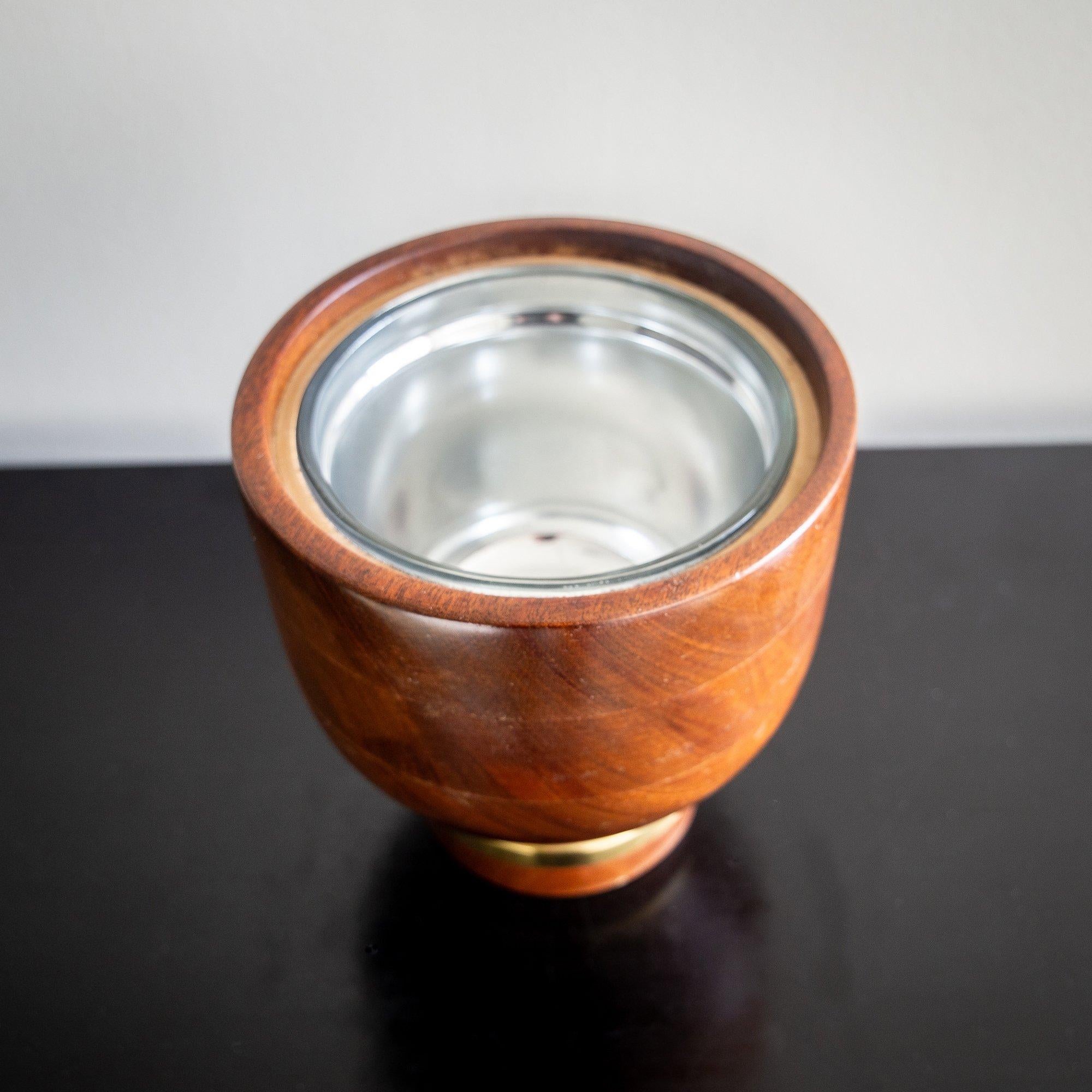 Exquisite work by Noll in turned walnut, with mounted brass base and glass liner.