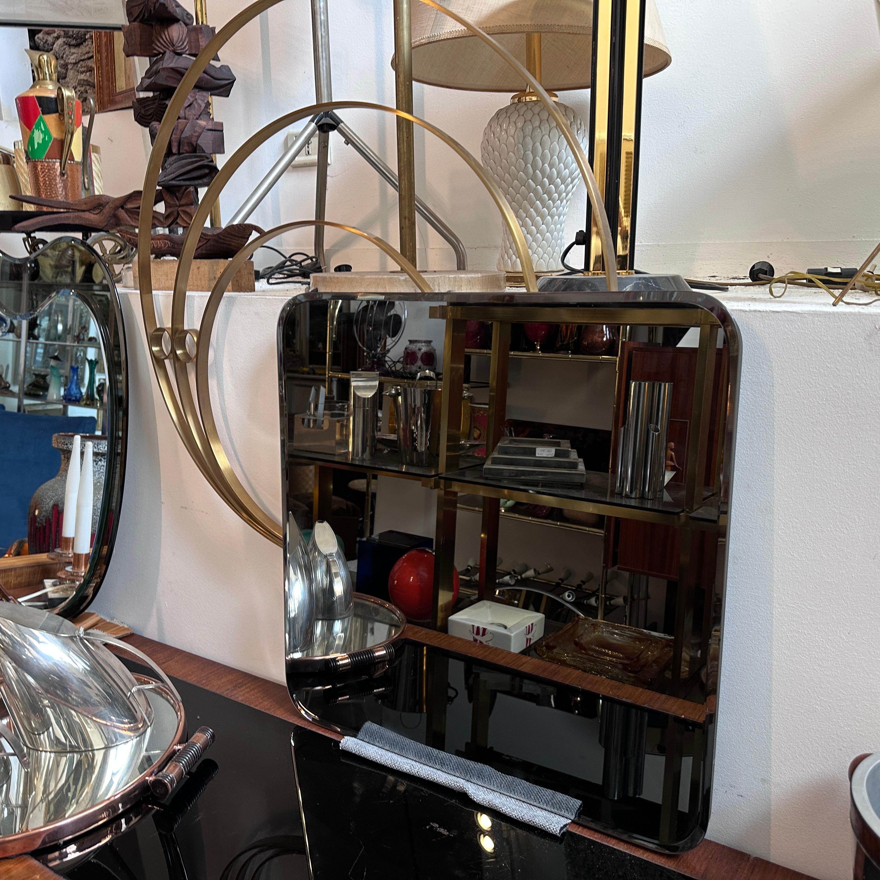 A stylish large wall mirror, designed by Luciano Frigerio and manufactured in Italy in the Sixties, features brass in its original patina, and the original glass is in very good condition overall. The wall mirror is a true testament to the design