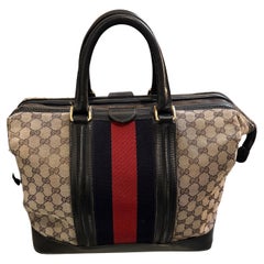 An Iconic 1980s Gucci Monogram Travel Bag with Signature Red and Blue Web Stripe