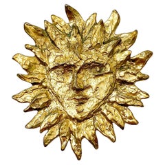 Broche emblématique Sun face en métal doré Yves Saint Laurent, France, années 1980