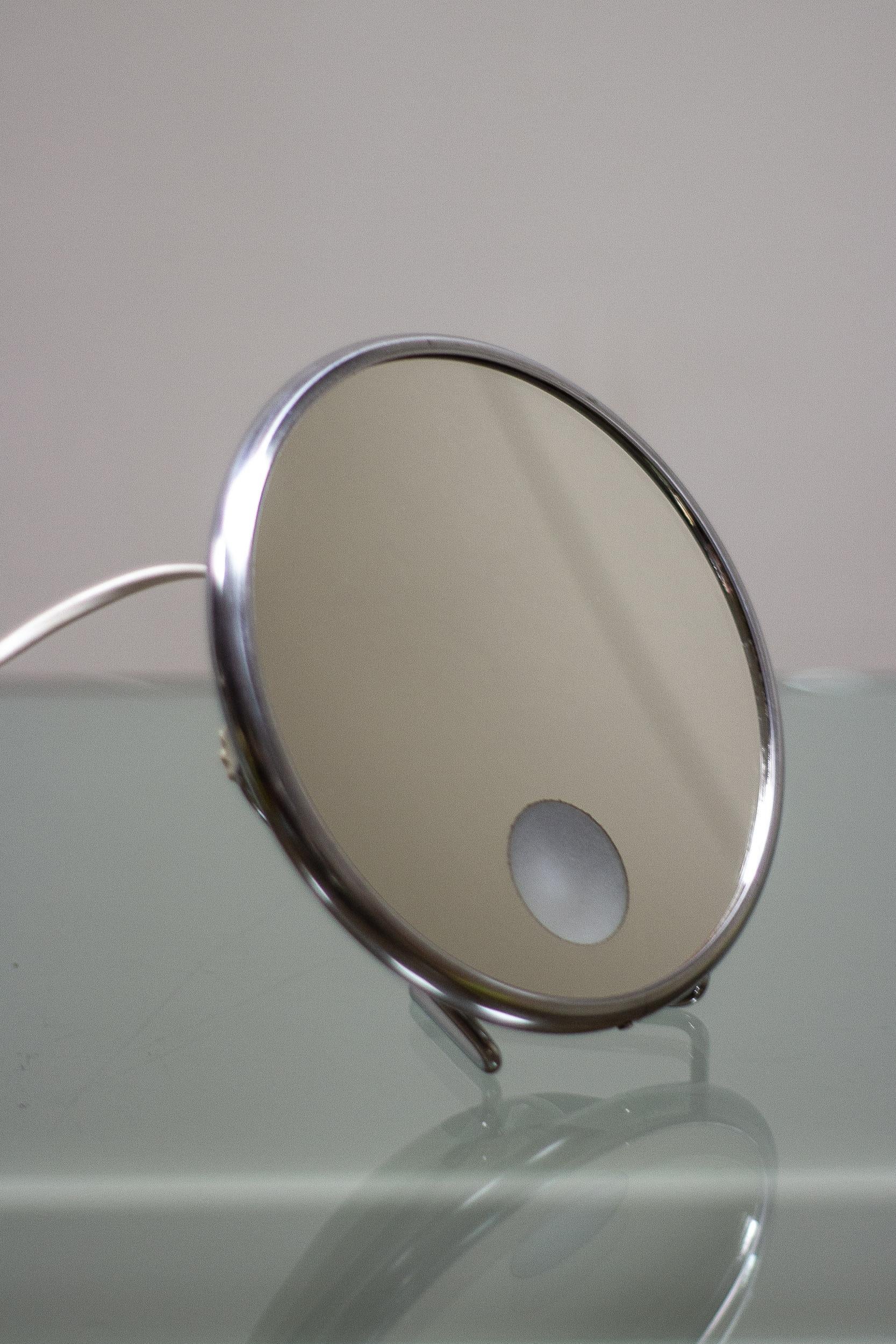 An illuminated vanity mirror by Arpin, Paris

This vanity mirror can stand on a flat surface or can be hung on the wall with various positions to the back plate. 

Made from a plastic back body and metal steel rim. 

Has been PAT tested.