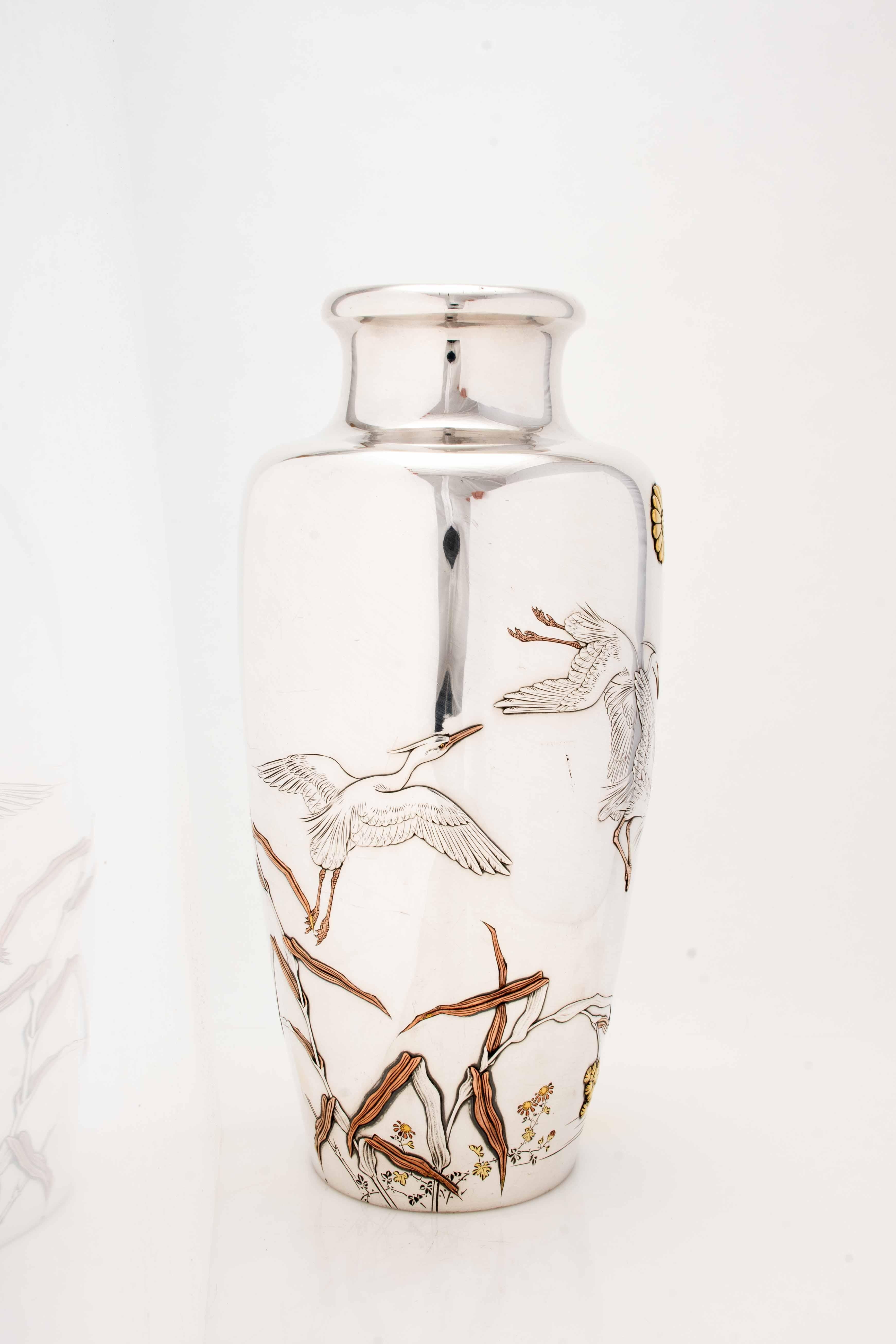 An imperial presentation vase in silver worked in kebori and repoussé, depicting some egrets in flight, signed Shoshu sai with Bi seal (Kobayashi Bikyo) and Miyamoto Kinsei brand with Junjin brand. On the neck of the vase is applied the golden monda
