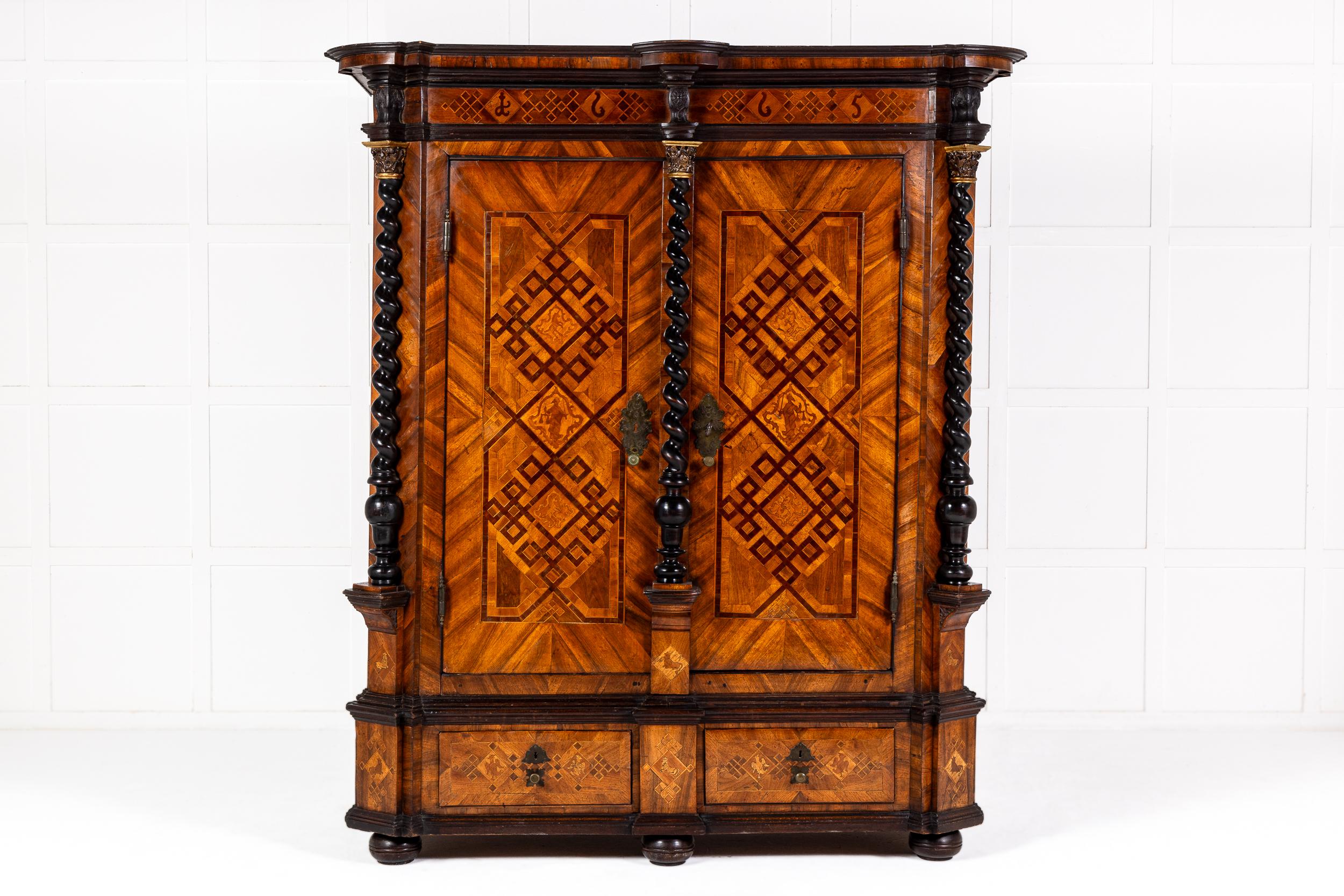 Un raro e importante Kas o Gabinetto tedesco in noce intarsiato, datato 1665 e che conserva la metalleria e la chiave originali.

Il cornicione sovrastante modellato con dettagli ebanizzati sopra un fregio intarsiato con disegni geometrici a