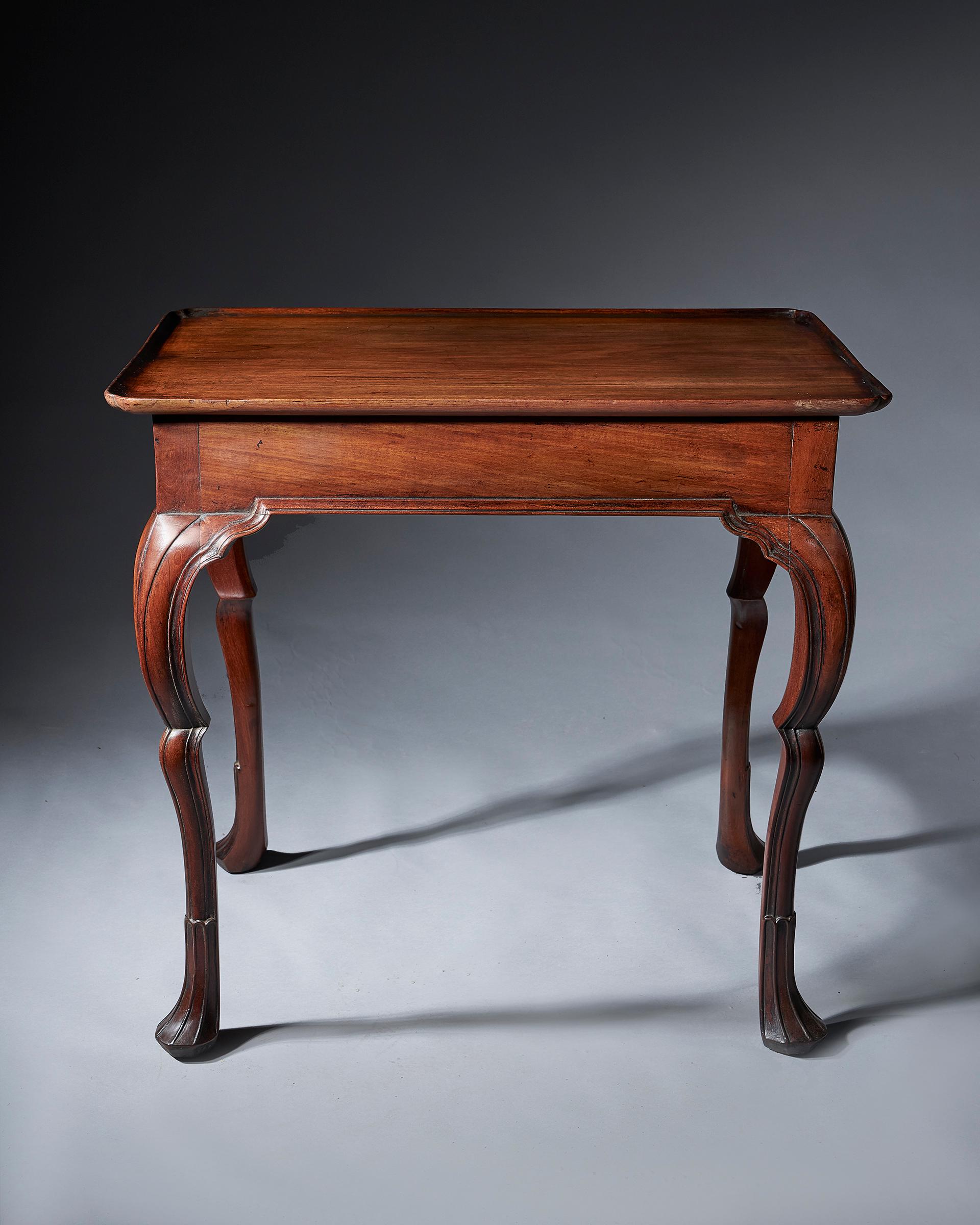 An important early 18th century Irish silver or tea table, circa 1740-1750. 

The solid mahogany top is relife carved to form a moulding with re-entrant corners. Similarly, the frieze is moulded to all faces allowing the table to stand freely. The