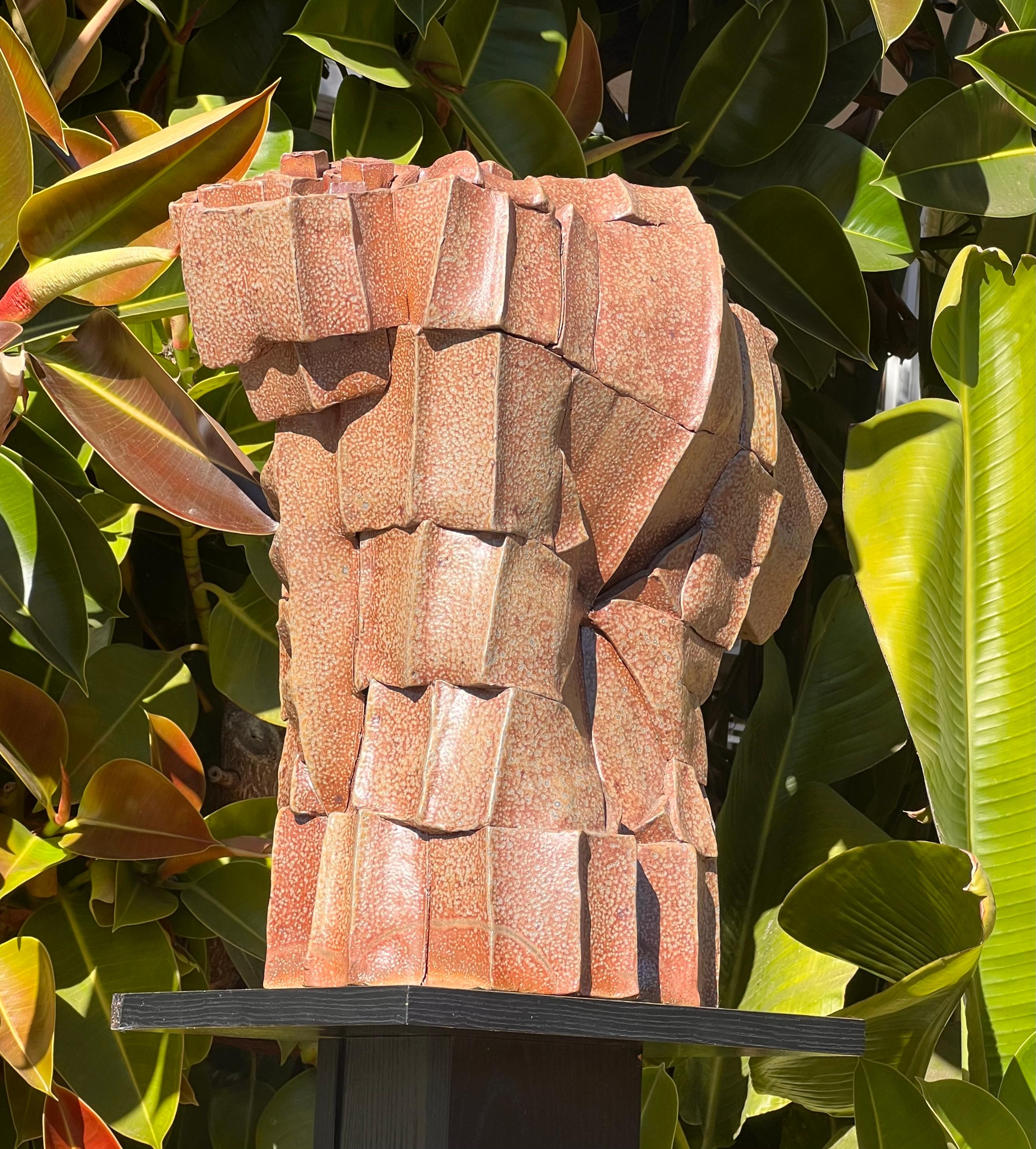 Torso masculino monumental de cerámica deconstruida, firmado por el artista, siglo XX. En tonos de pesche quemado, albaricoque y siena, esta impresionante escultura personifica el cubismo en forma tridimensional, con sus ángulos salientes y su