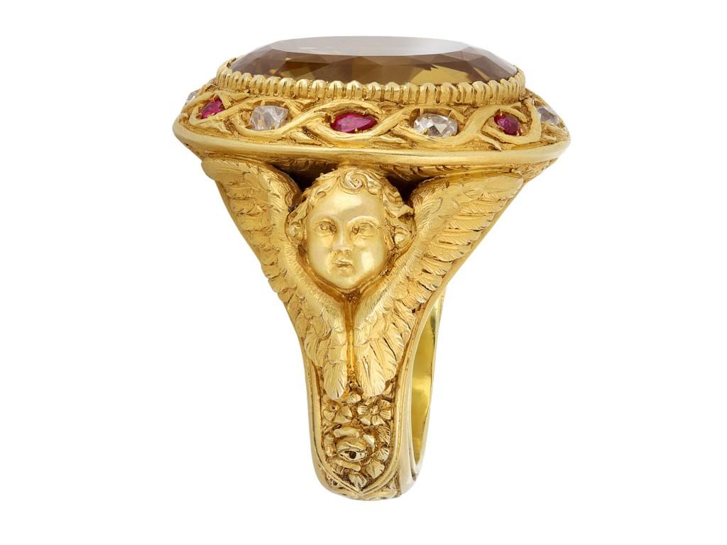 An important early Bulgari ring. Set centrally with an impressive oval old cut citrine in an open back rubover setting with an approximate weight of 24.00 carats, further encircled with six round and drop shape old cut natural unenhanced Burmese