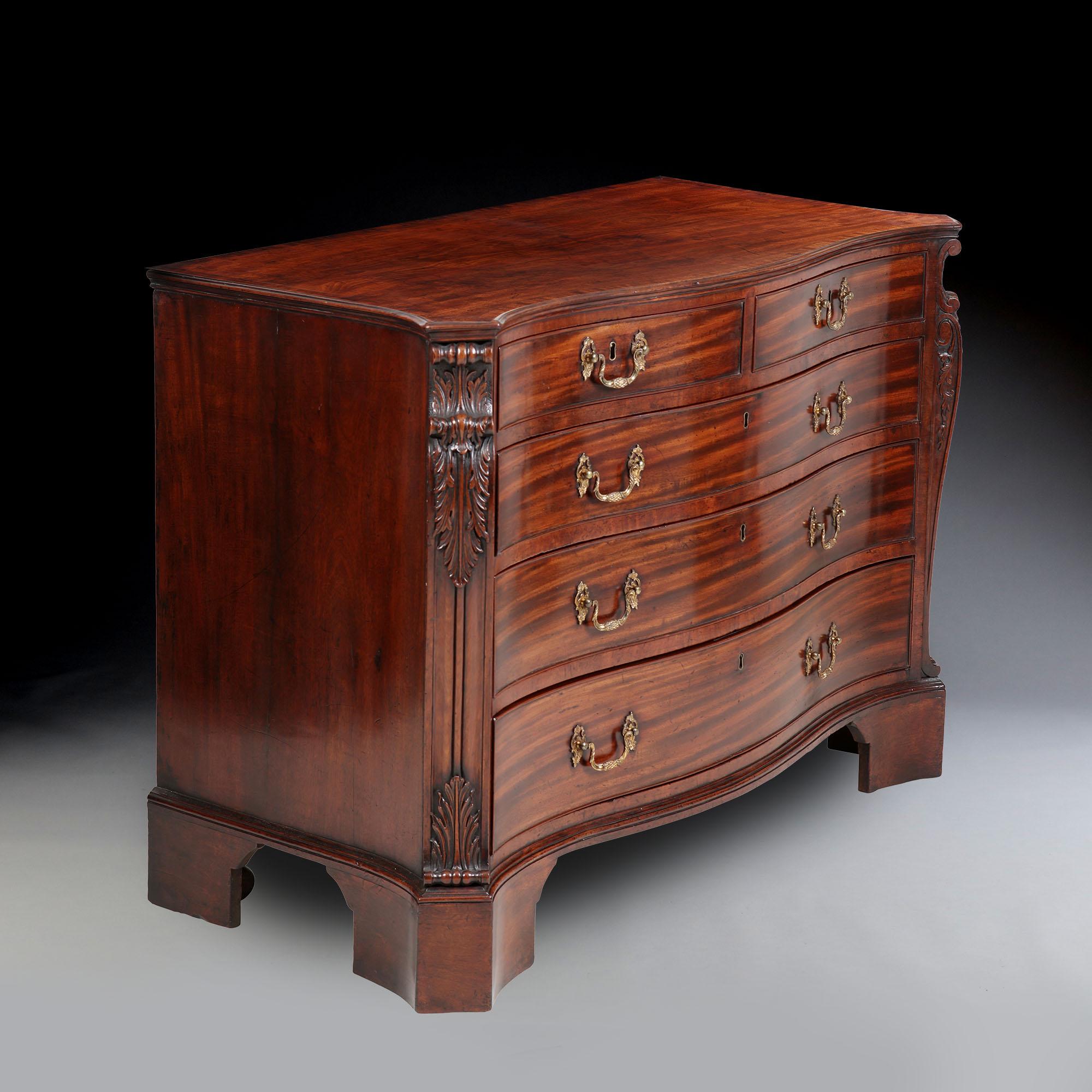 An important George III mahogany commode attributed to William Gomm. The serpentine mahogany top with a crossbanded edge, above three long and two short drawers with gilt Rococo handles, flanked by superbly carved angle supports, with shaped sides,