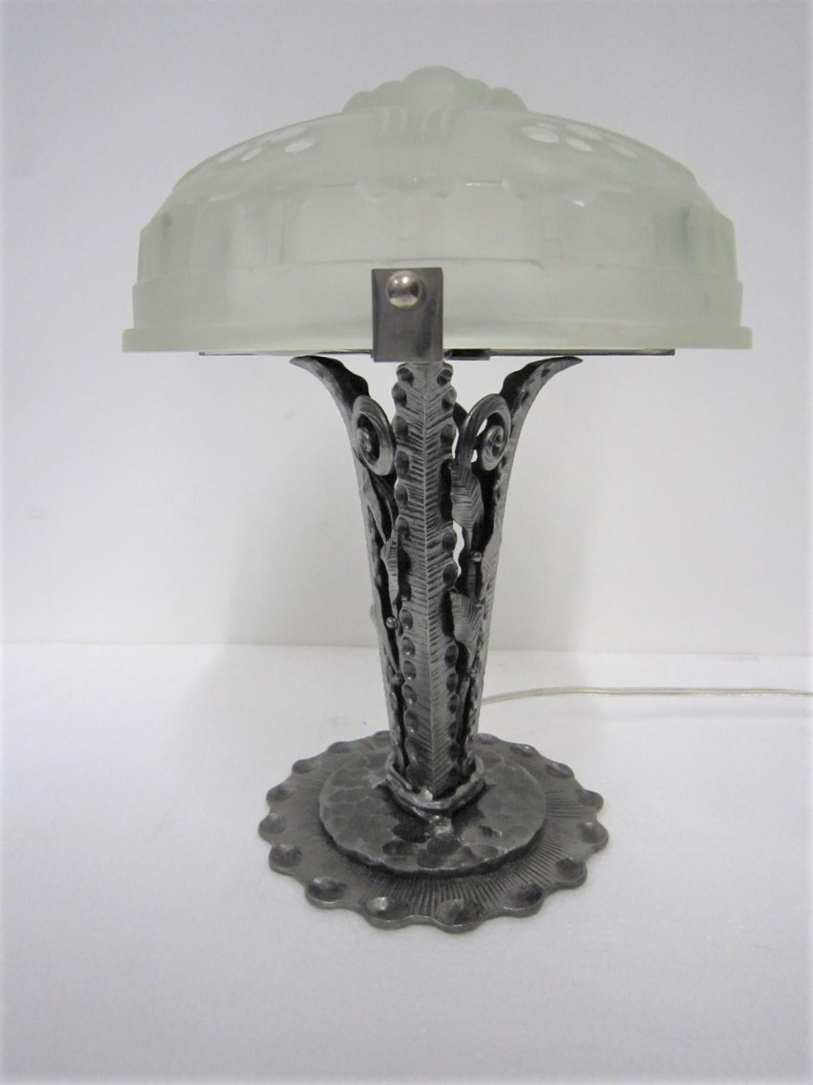 A French Art Deco table lamp signed Sabino
Marius Ernest Sabino (1878-1961)
The shade features Art Deco geometric patterns in frosted and polished art glass.
The glass is mounted on its original hand-hammered / fer forge, beautifully detailed