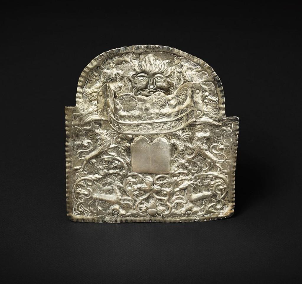 Un esempio raro e riccamente simbolico di Judaica dell'Europa orientale del XVIII secolo, questo scudo Torah (tas) proviene dalla Galizia, una regione storica che comprende parti delle attuali Polonia e Ucraina. Realizzati da abili artigiani ebrei,