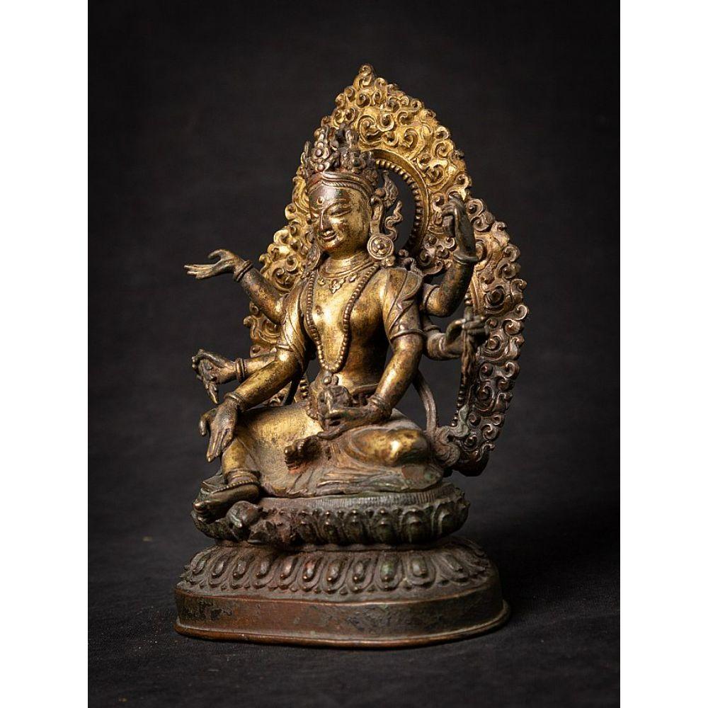 Material: bronze
19 cm high 
13 cm wide and 11 cm deep
Weight: 1.423 kgs
Fire gilded with 24 krt. gold
Originating from Nepal
Dating from +/- 1700
Seated in lalitasana, her six arms radiating around her holding flowing gems, the vase of amrita, a