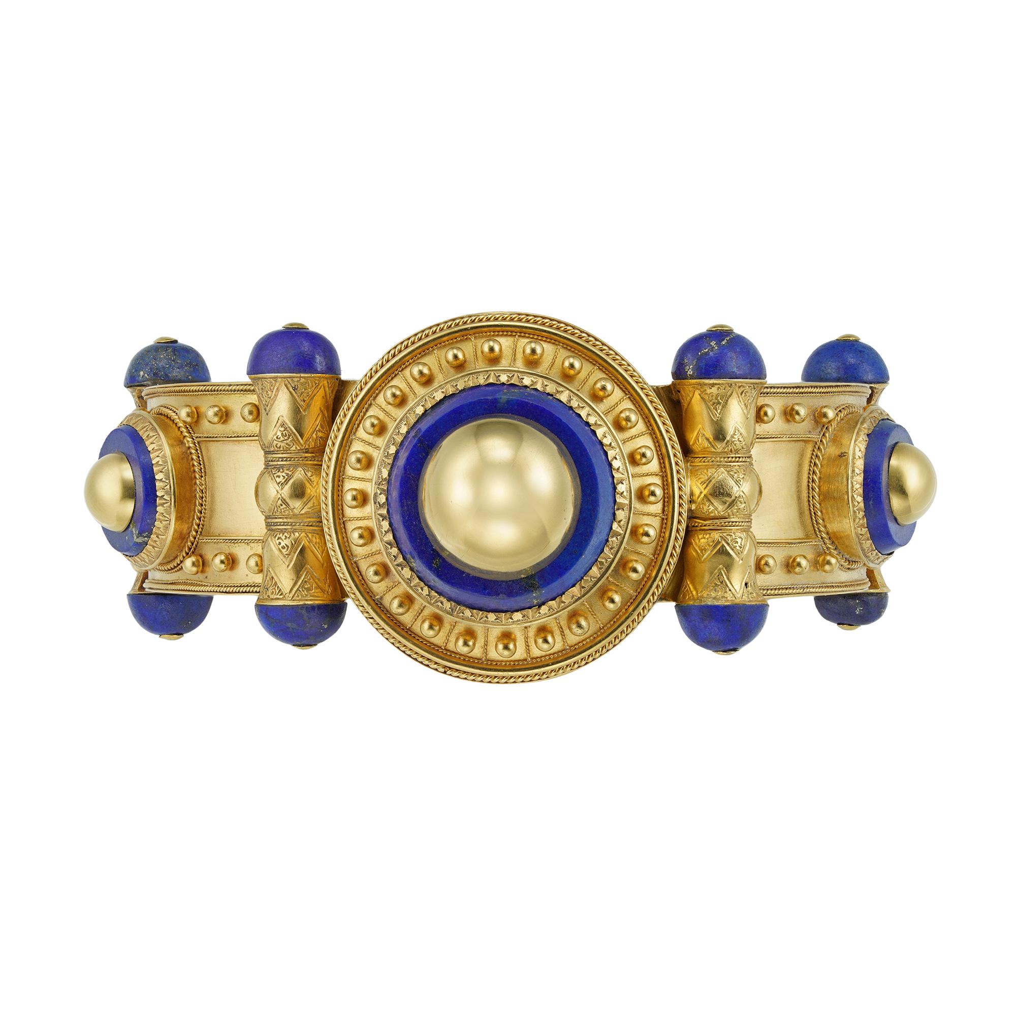 An Important gold and lapis bangle by Cartier, set to the centre with a gold dome inlayed in a lapis plaque, surrounded by Etruscan style wire and bead-work decorations, the hinged bangle composed of four panels each bearing a smaller gold dome