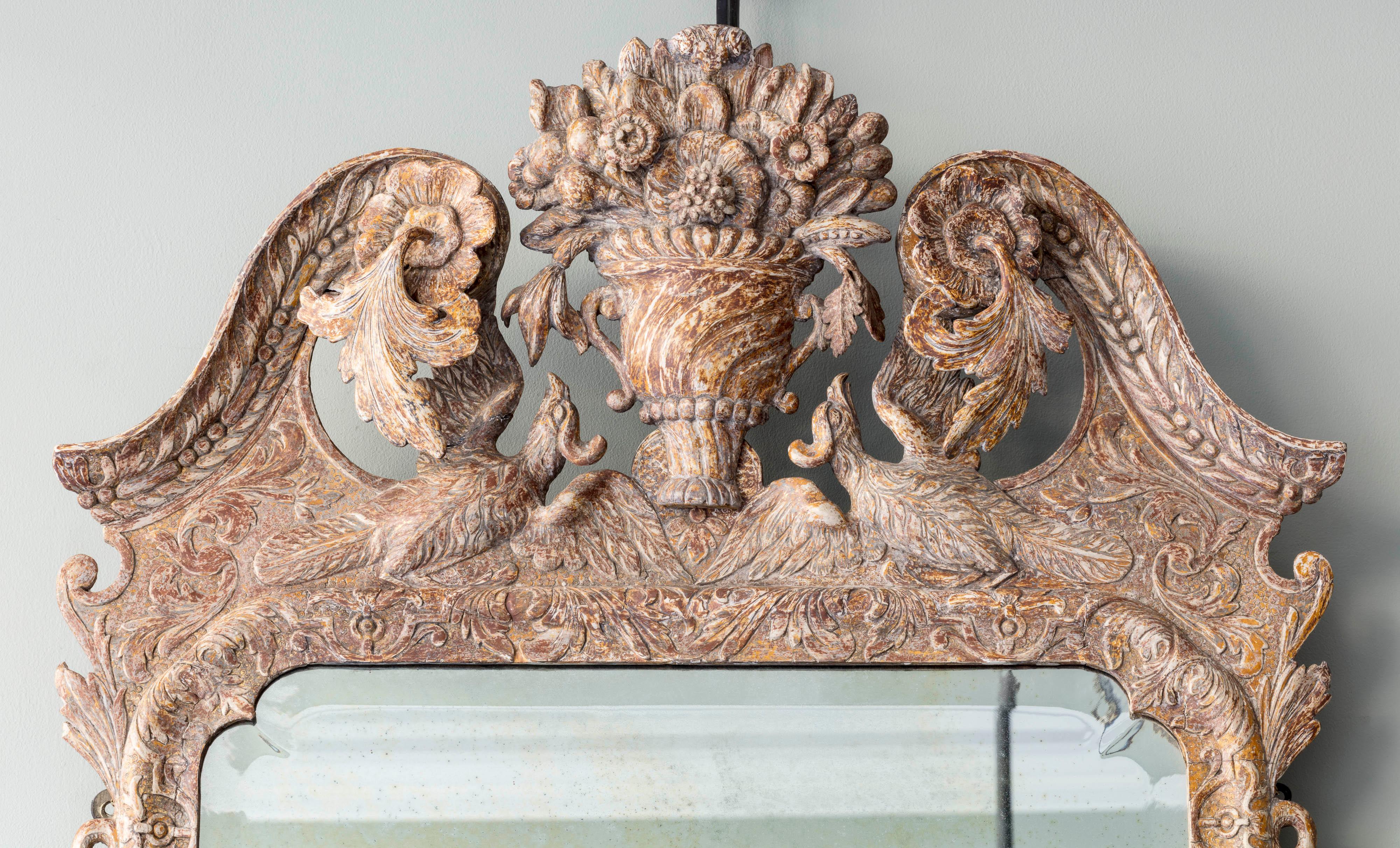 Retaining its original gilding, the swan neck top mounted with carved rosettes and trailing acanthus outside a central basket of flowers above swooping birds. The later rectangular bevelled plate supported by carved drapes tassels and serpents,