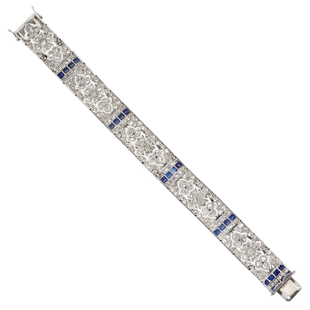 An important late  Belle Époque pierced sapphire and diamond plaque bracelet, consisting of five rectangular pierced plaques of a floral design, set throughout with old-cut diamonds, estimated to weigh a total  of 17 carats, separated by a run of