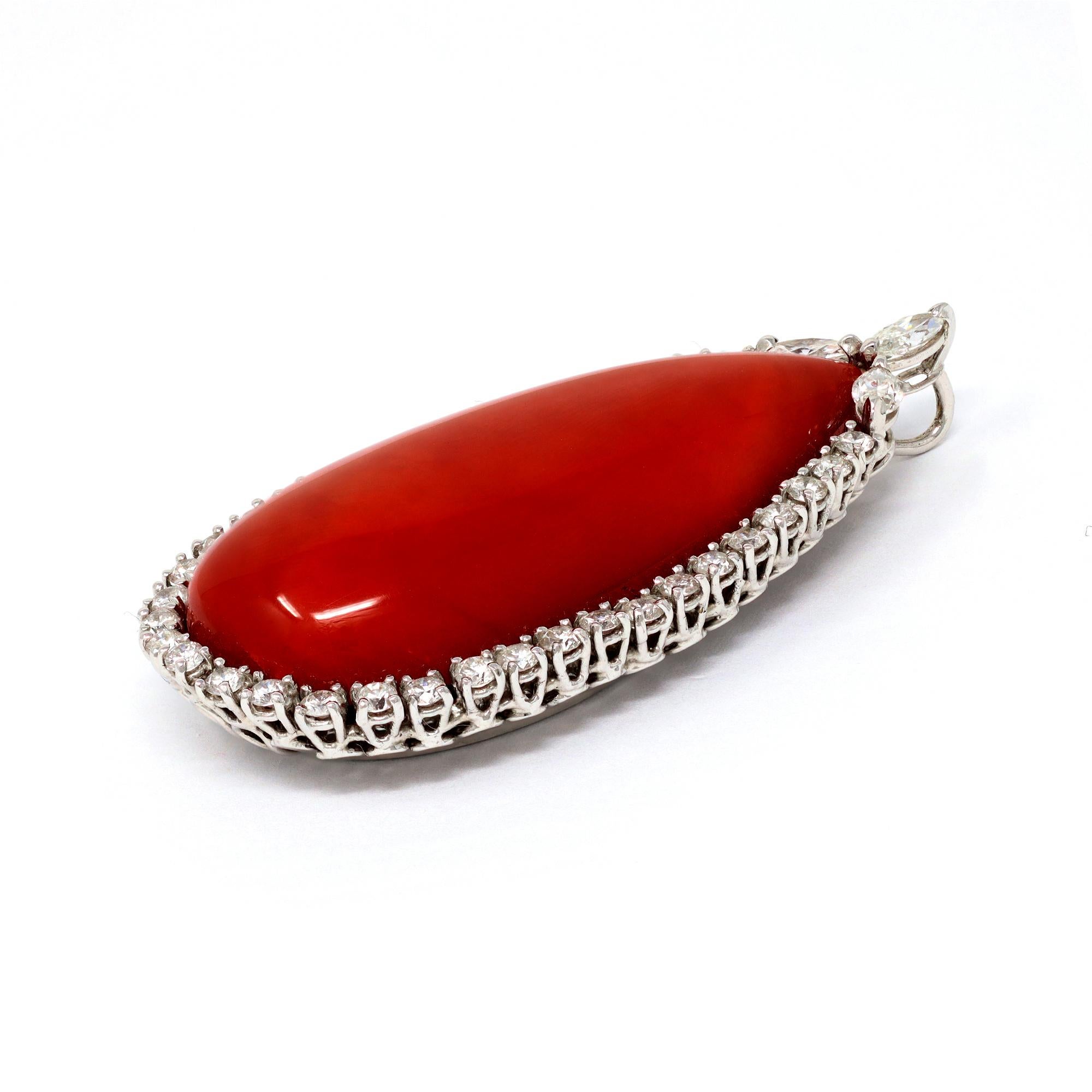 A natural untreated deep red coral and diamonds pendant circa 1970. The 18 karat white gold pendant features an important and large  drop shape red coral surrounded by a halo of diamonds and set with 3 marquise shape diamonds at the top. The